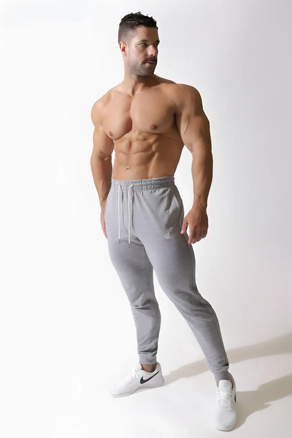 Gray spirit joggers with a drawstring waistband and subtle brand logo on the left thigh for athletic wear