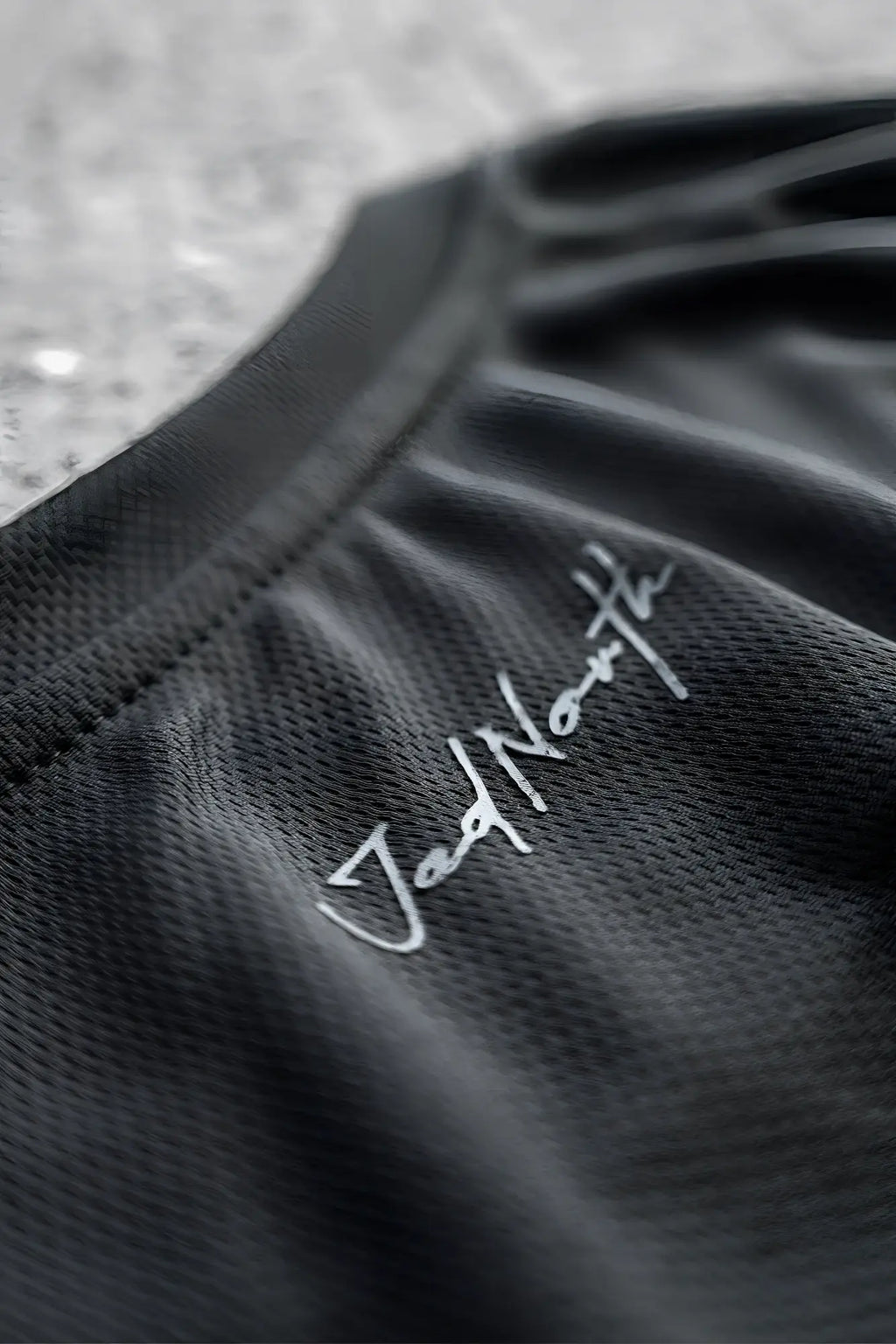 Black jed north tactical fast-dry training tank top with silver cursive embroidery on the neckline in obsidian black
