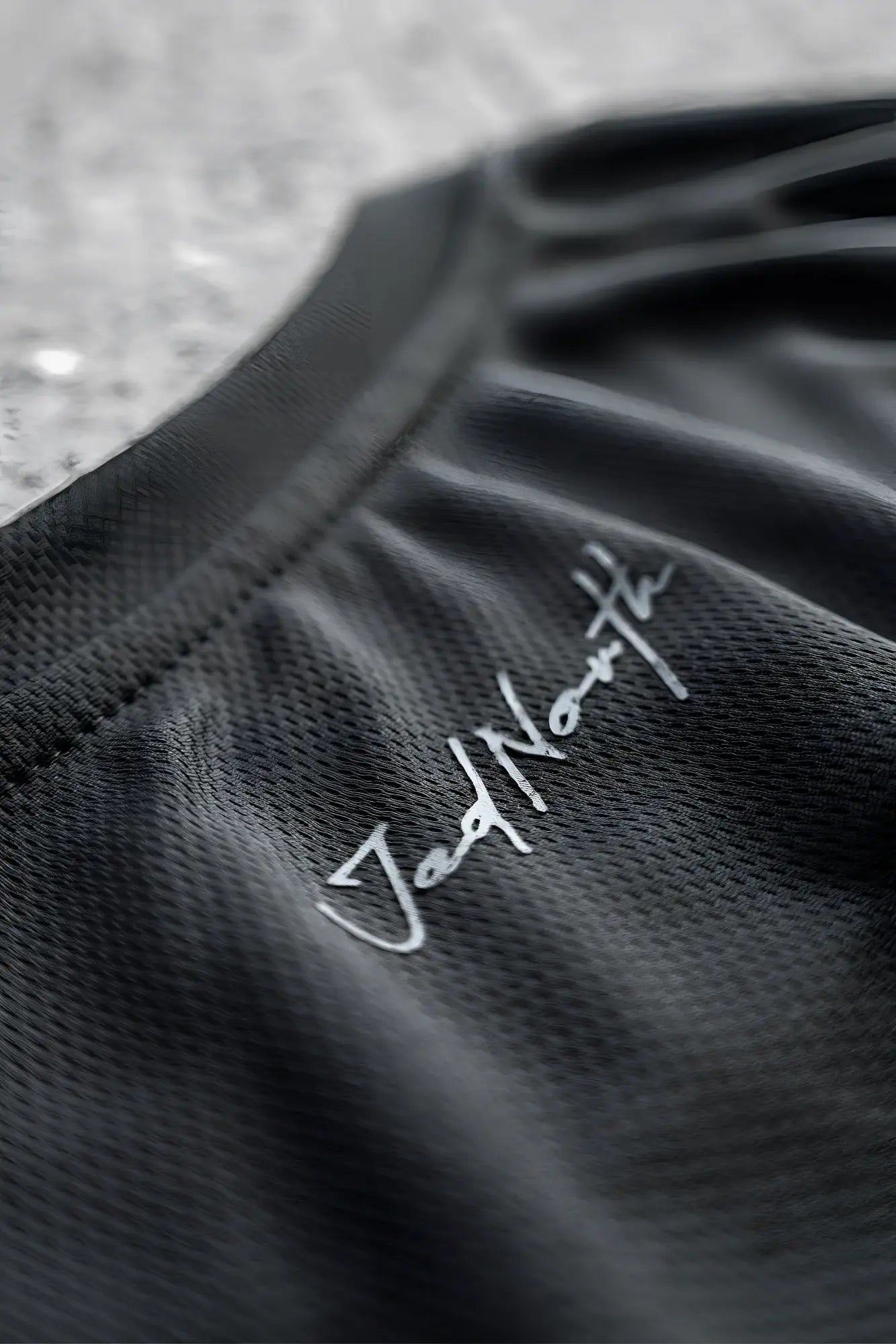 Black jed north tactical fast-dry training tank top with silver cursive embroidery on the neckline in obsidian black