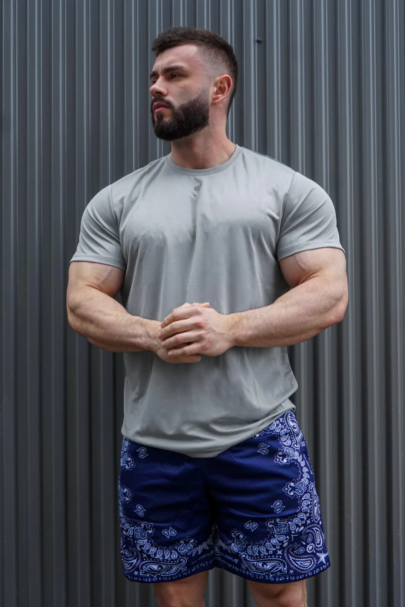 A man wearing a jed north tactical fast-dry training t-shirt in polar silver with navy blue bandana shorts
