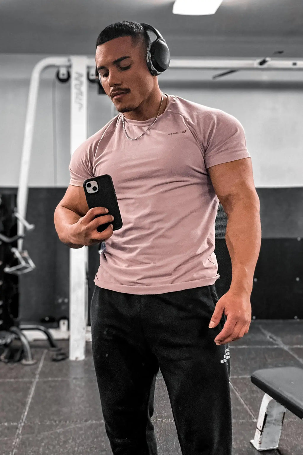A man wearing a salmon jed north titan 2.0 muscle-fit short-sleeved t-shirt with subtle chest branding