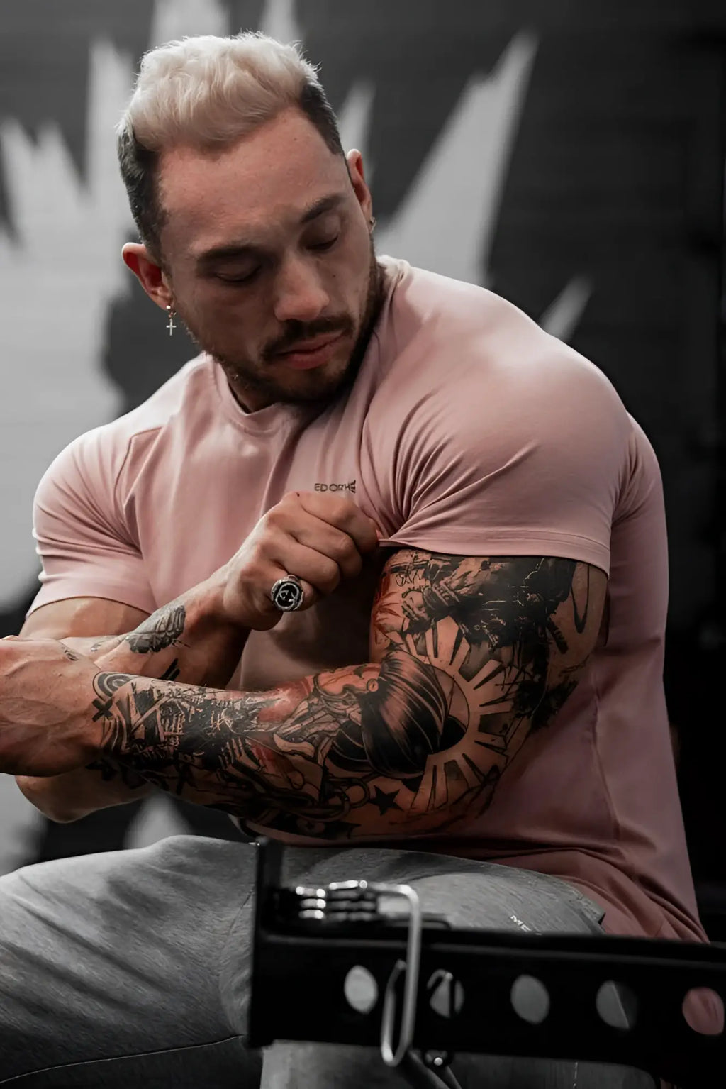 A man wearing a muscular fit salmon Jed North Titan 2.0 t-shirt with sprint print on the chest