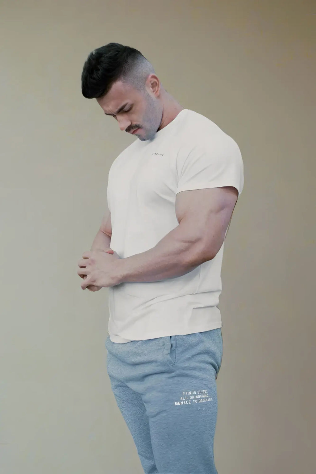 A man wearing a white Jed North Titan 2.0 muscle-fit short-sleeved t-shirt with subtle chest branding