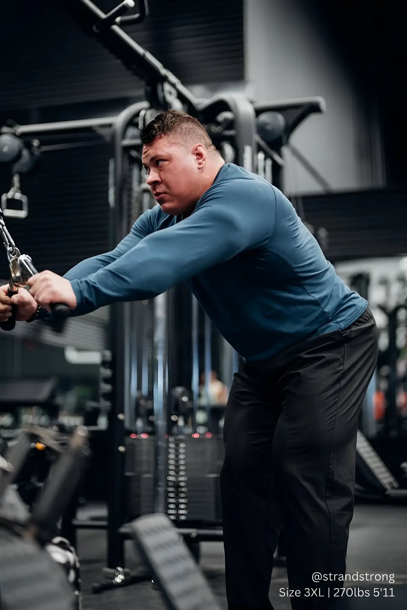 A muscular man wearing a steel blue Jed North Titan muscle-fit long sleeve t-shirt performing a cable row exercise