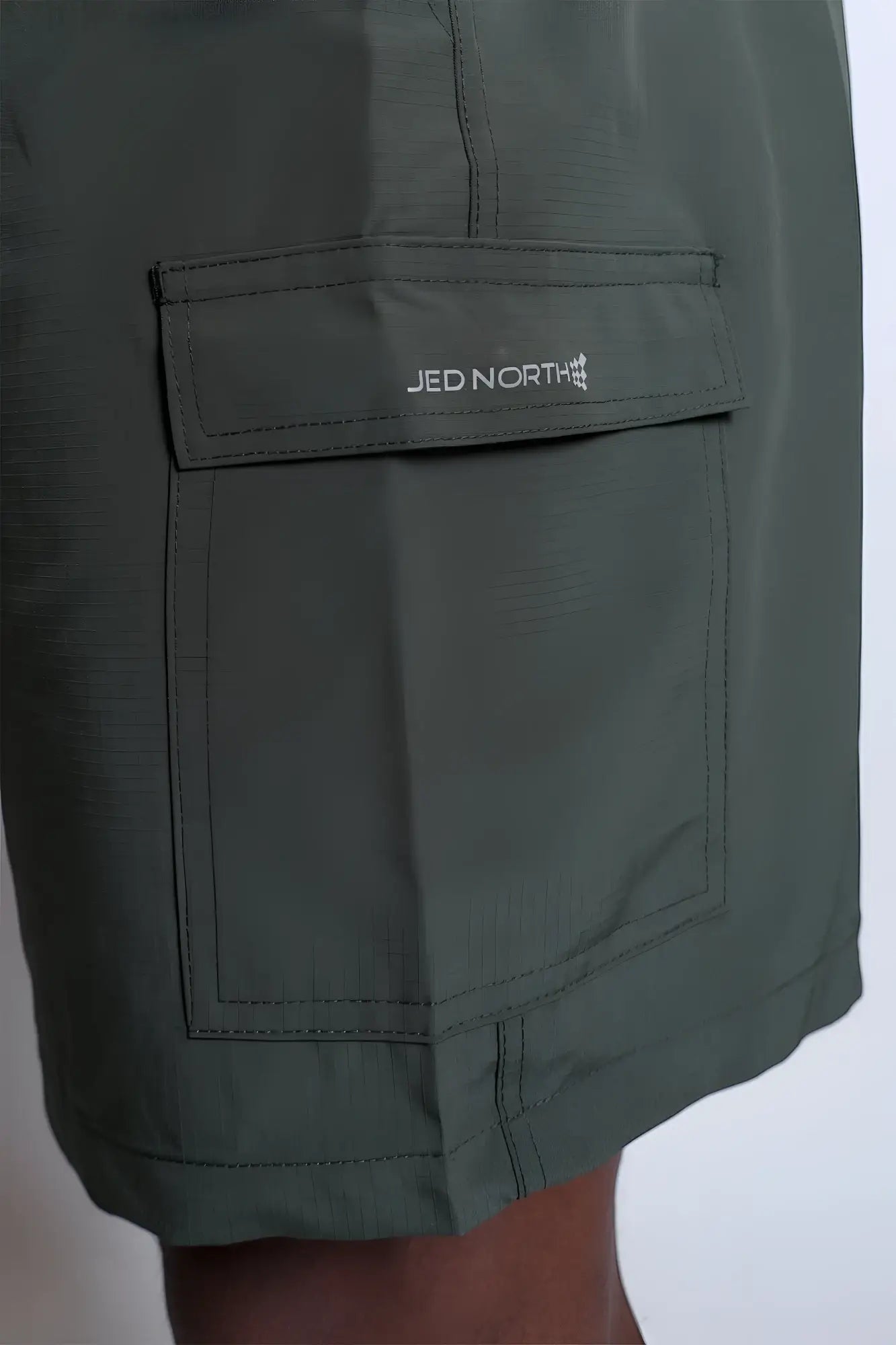 Olive green trek 4.5 inch cargo shorts with stitched jed north logo pocket perfect for outdoor use