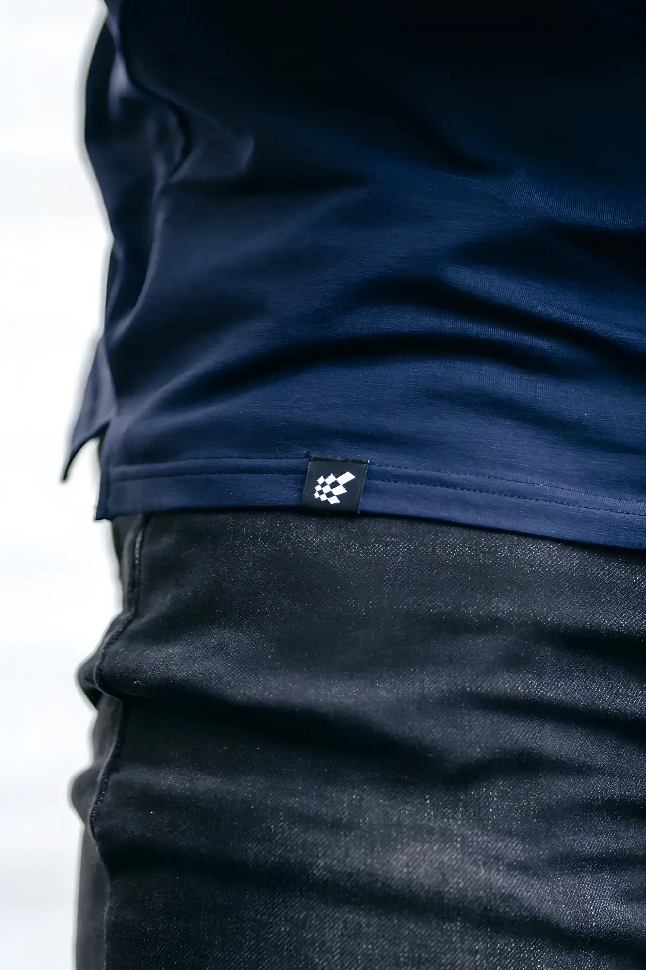 Dark blue cotton v neck muscle-fit t-shirt with small black and white checkered logo tag at the hem