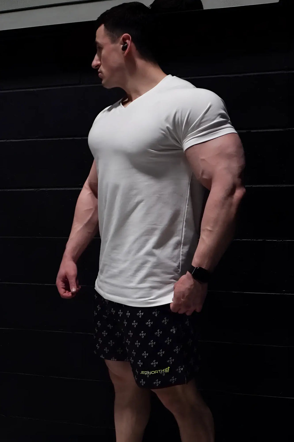 A man wearing a white Jed North v neck muscle-fit short-sleeved t-shirt showcasing its slim fit design