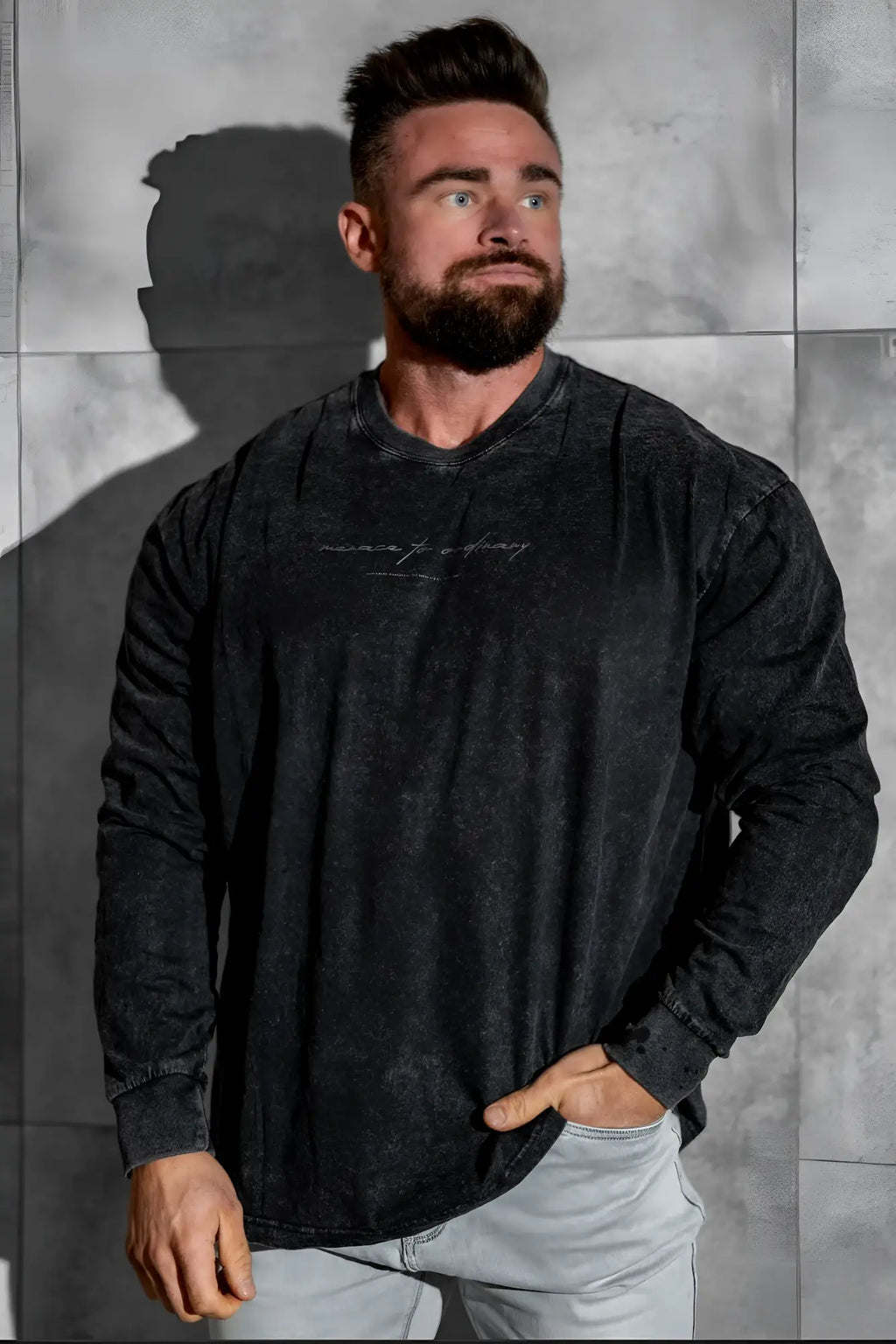 Black vintage wash long sleeve t-shirt with faded distressed texture and subtle white cursive lettering on chest