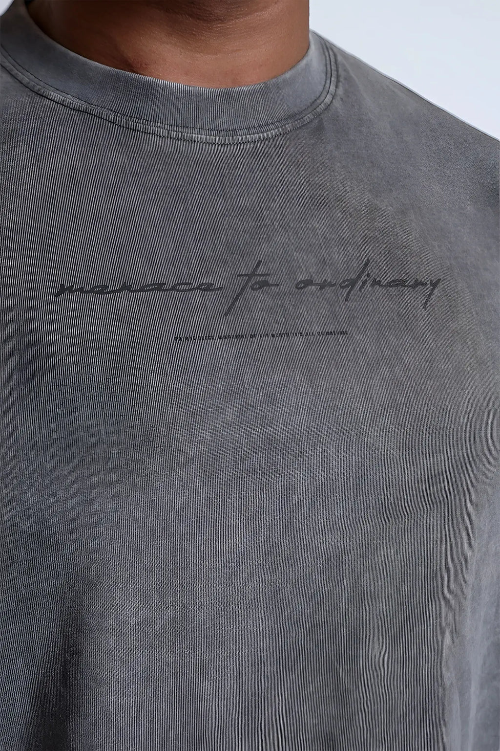 Vintage wash long sleeve t-shirt in storm gray cotton with a textured faded finish and black cursive manaca to ordinary text