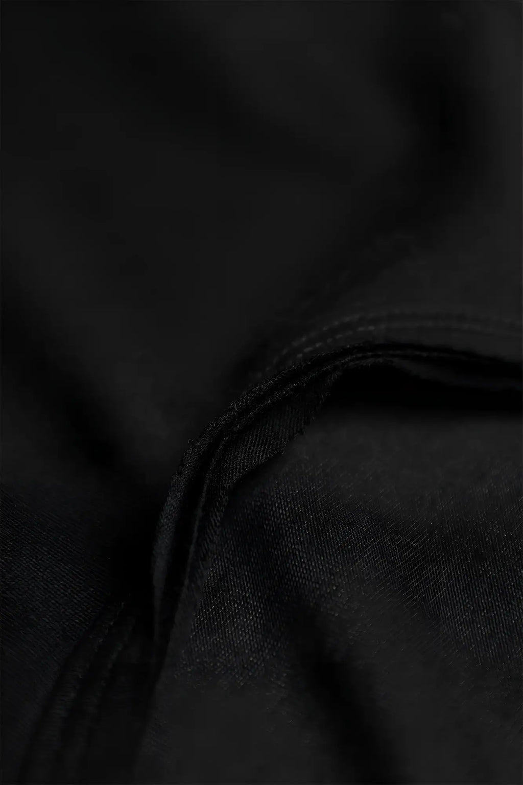Black fabric with subtle texture and neatly stitched seam on the vital raw-hem tank top 2.0 in black