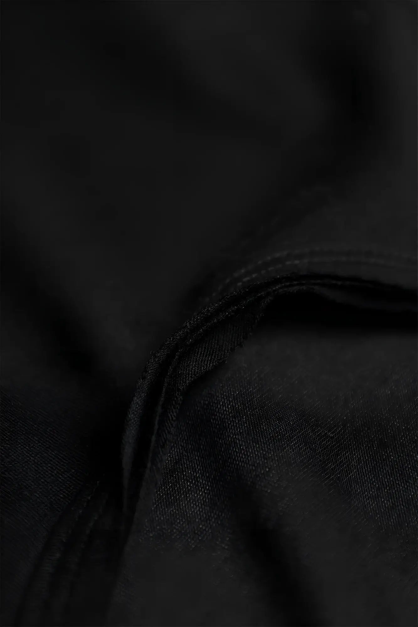 Black fabric with subtle texture and neatly stitched seam on the vital raw-hem tank top 2.0 in black