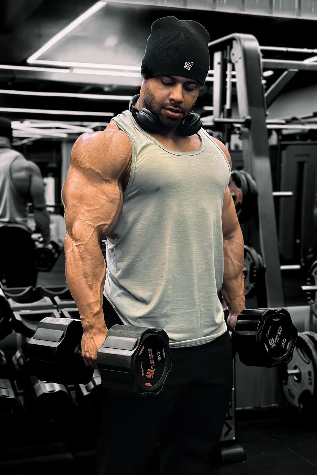 Black dumbbell with red and white branding beside a gray jed north vital raw-hem tank top 2.0 front view