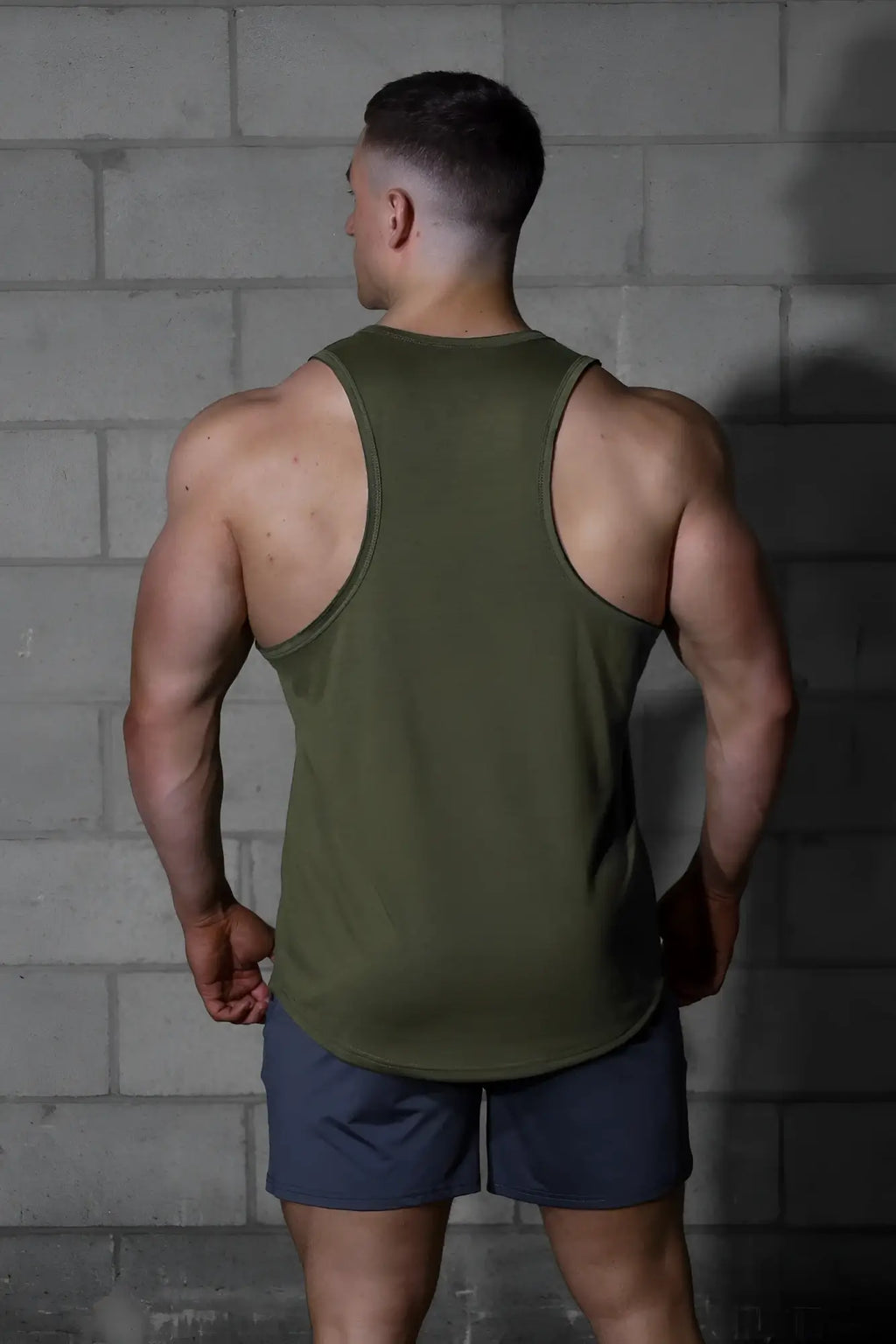 Olive green sleeveless athletic tank top with raw hem by jed north designed for workout and casual wear