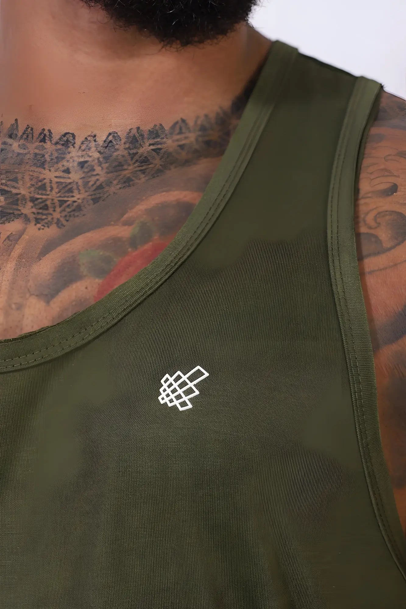 Olive green sleeveless tank top with small white geometric logo embroidered on left chest by jed north