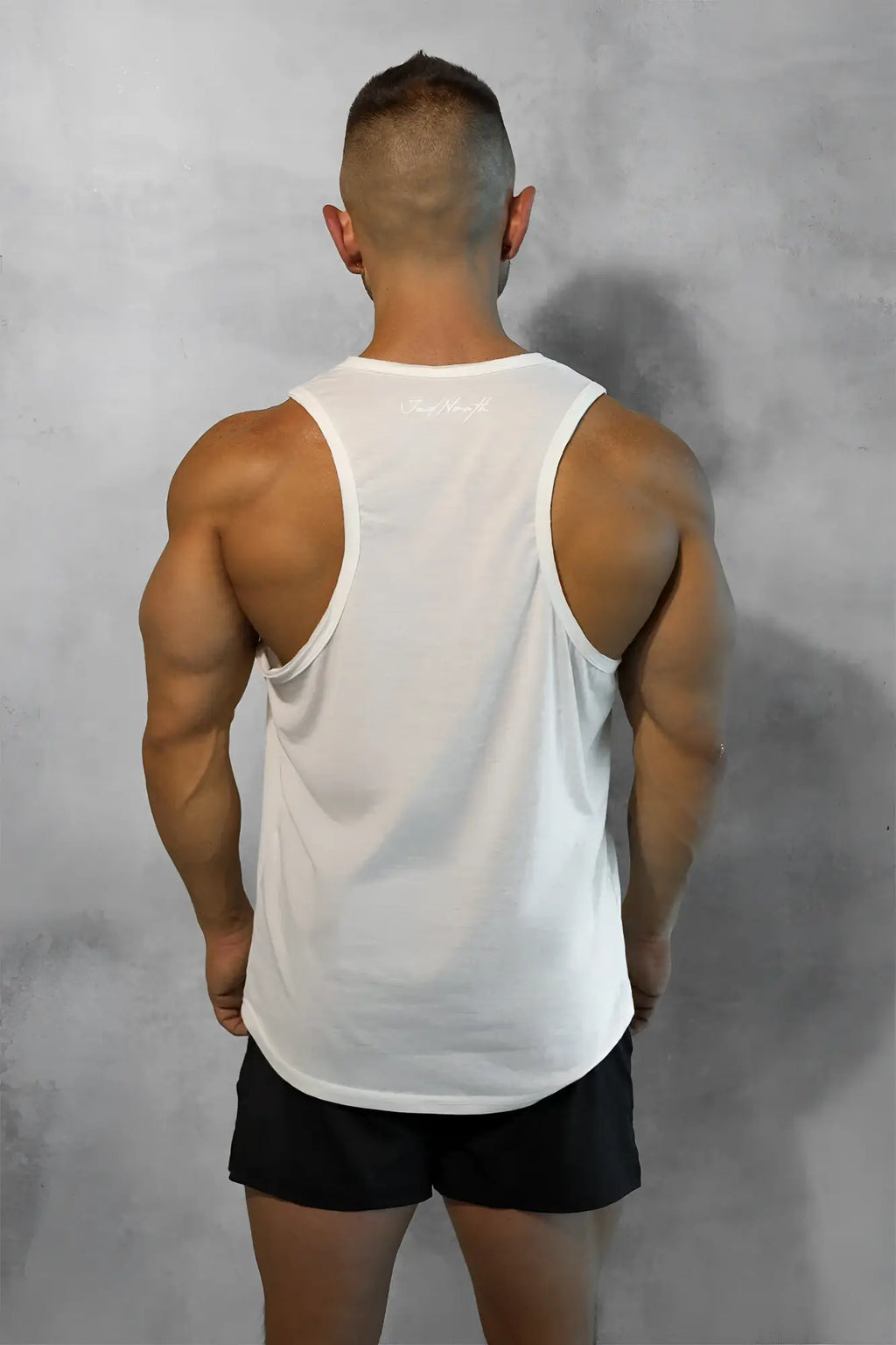 White sleeveless athletic tank top with subtle upper back logo shown from the back in vital raw-hem tank top 2.0