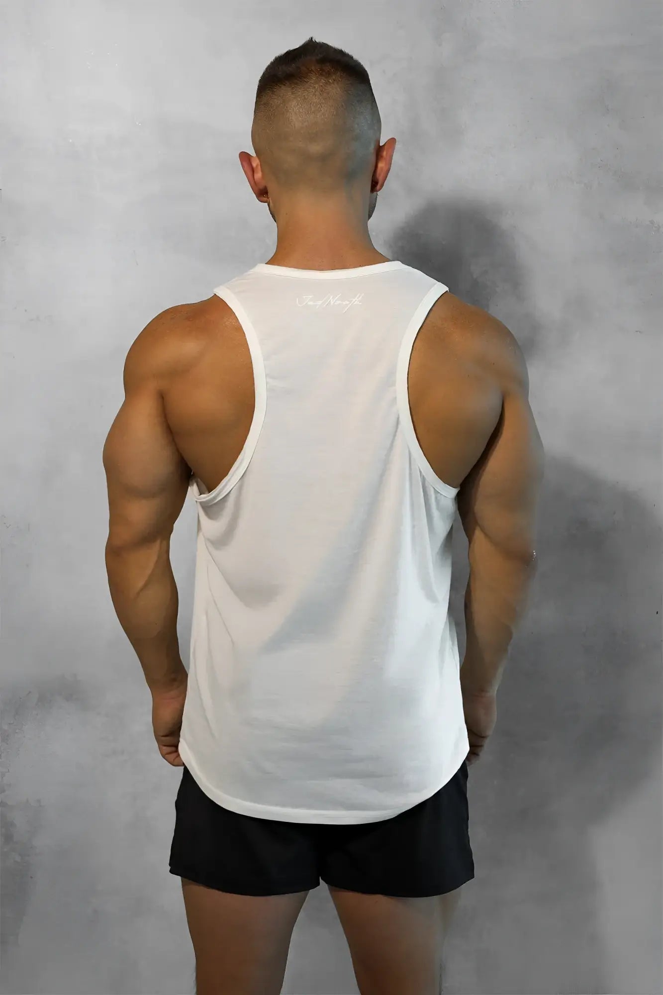 White sleeveless athletic tank top with subtle upper back logo shown from the back in vital raw-hem tank top 2.0