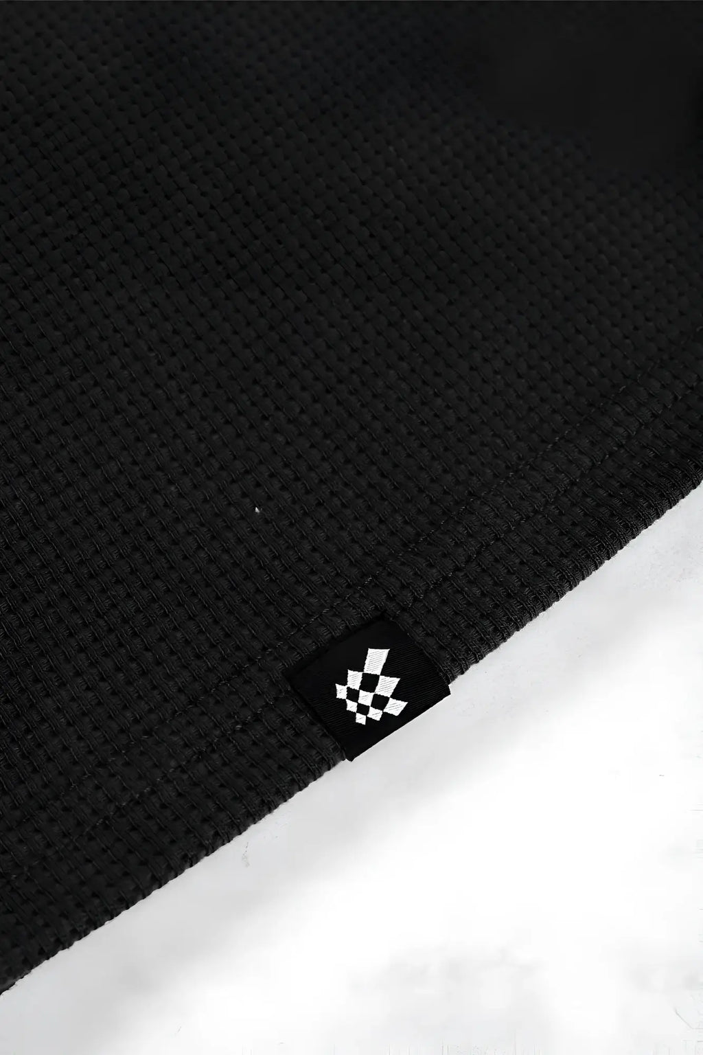 Black waffle henley t shirt featuring waffle knit fabric and a small black and white checkered logo tag