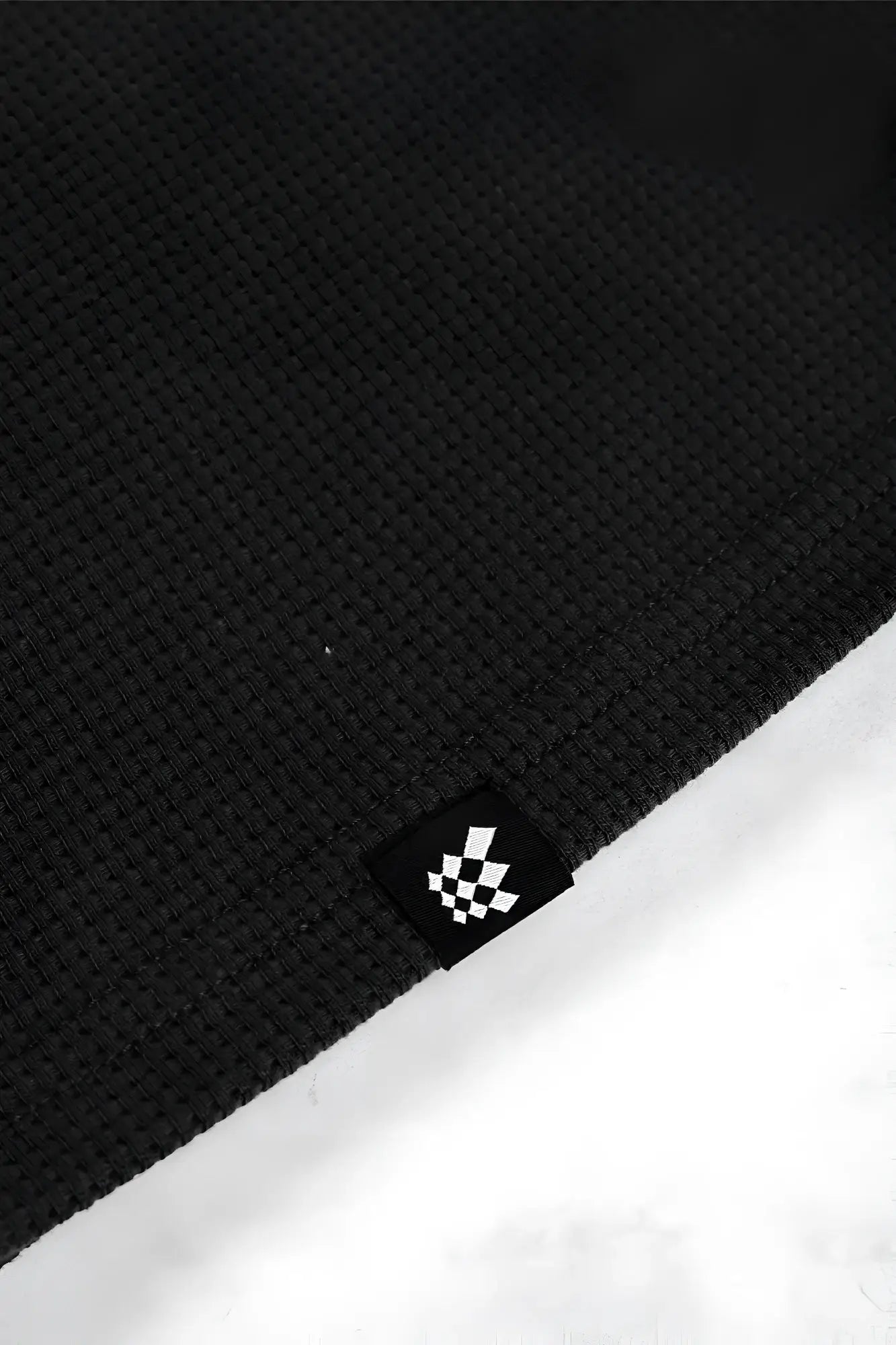 Black waffle henley t shirt featuring waffle knit fabric and a small black and white checkered logo tag