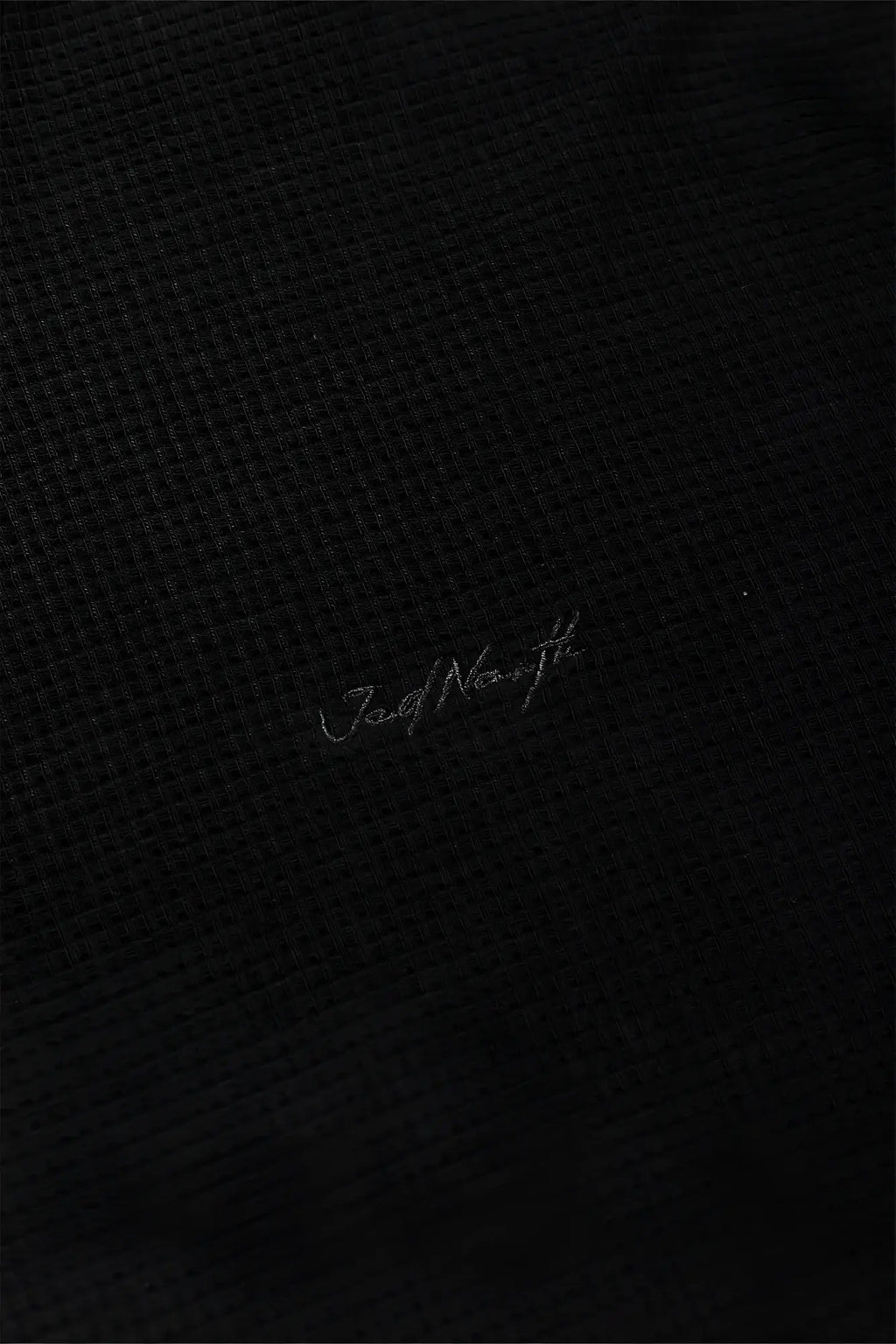 Black waffle henley t-shirt with textured fabric and subtle silver jad north embroidery on the front
