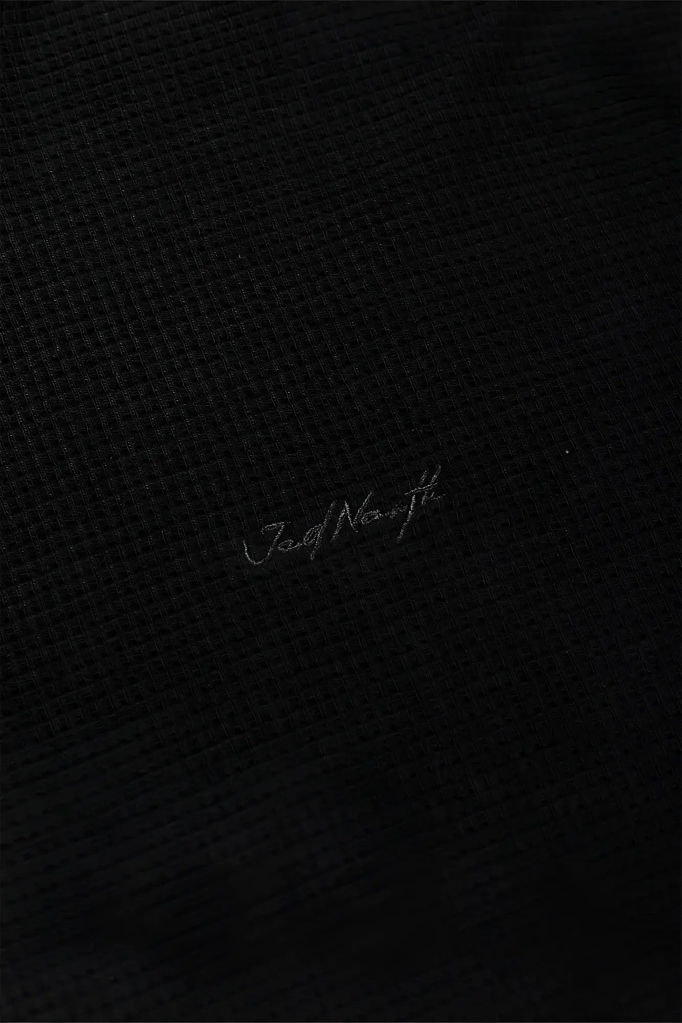 Black waffle henley t-shirt with textured fabric and subtle silver jad north embroidery on the front