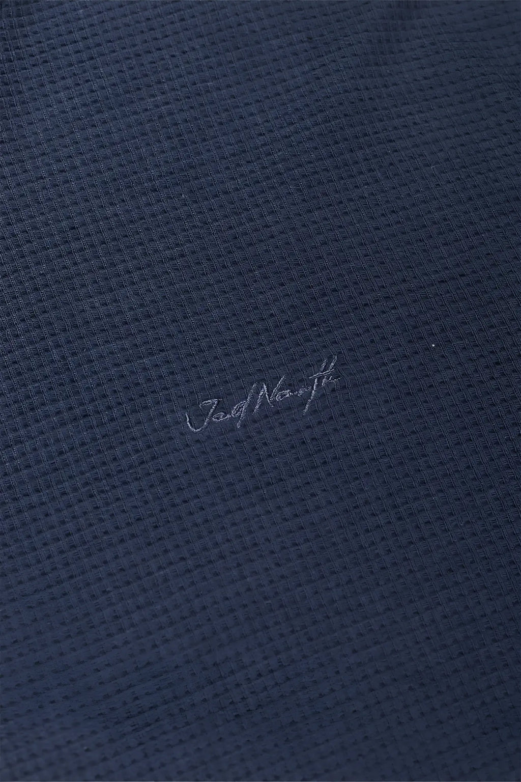 Dark blue waffle-knit polo shirt with subtle jord norrth embroidery in a waffle henley t-shirt style dusty blue color