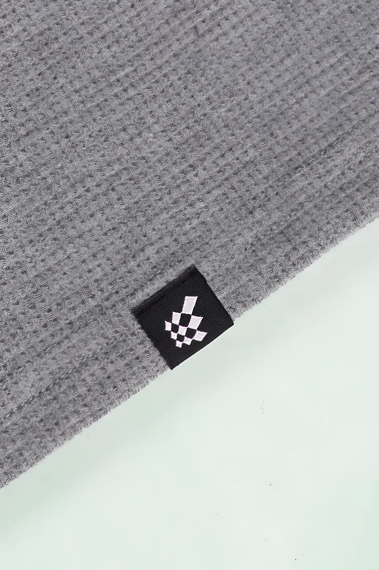 Waffle henley t-shirt in light gray gray waffle-knit fabric with black woven label and white checkered flag logo