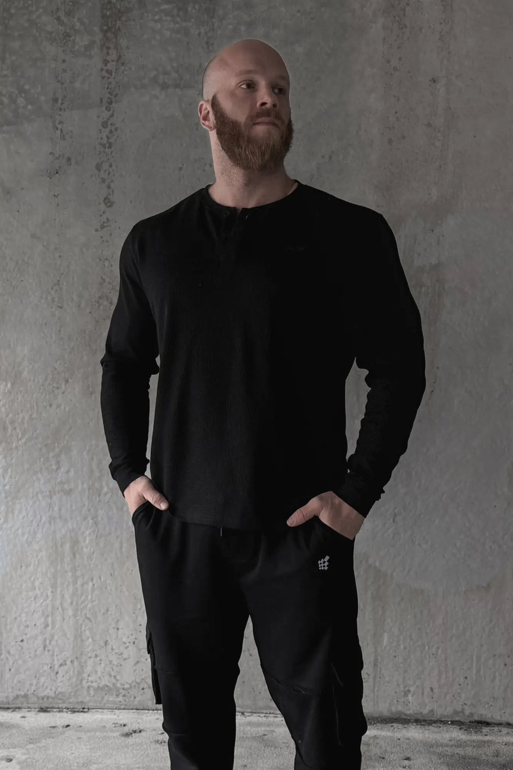 Black waffle knit henley long sleeve t-shirt with round neckline and subtle stitching details