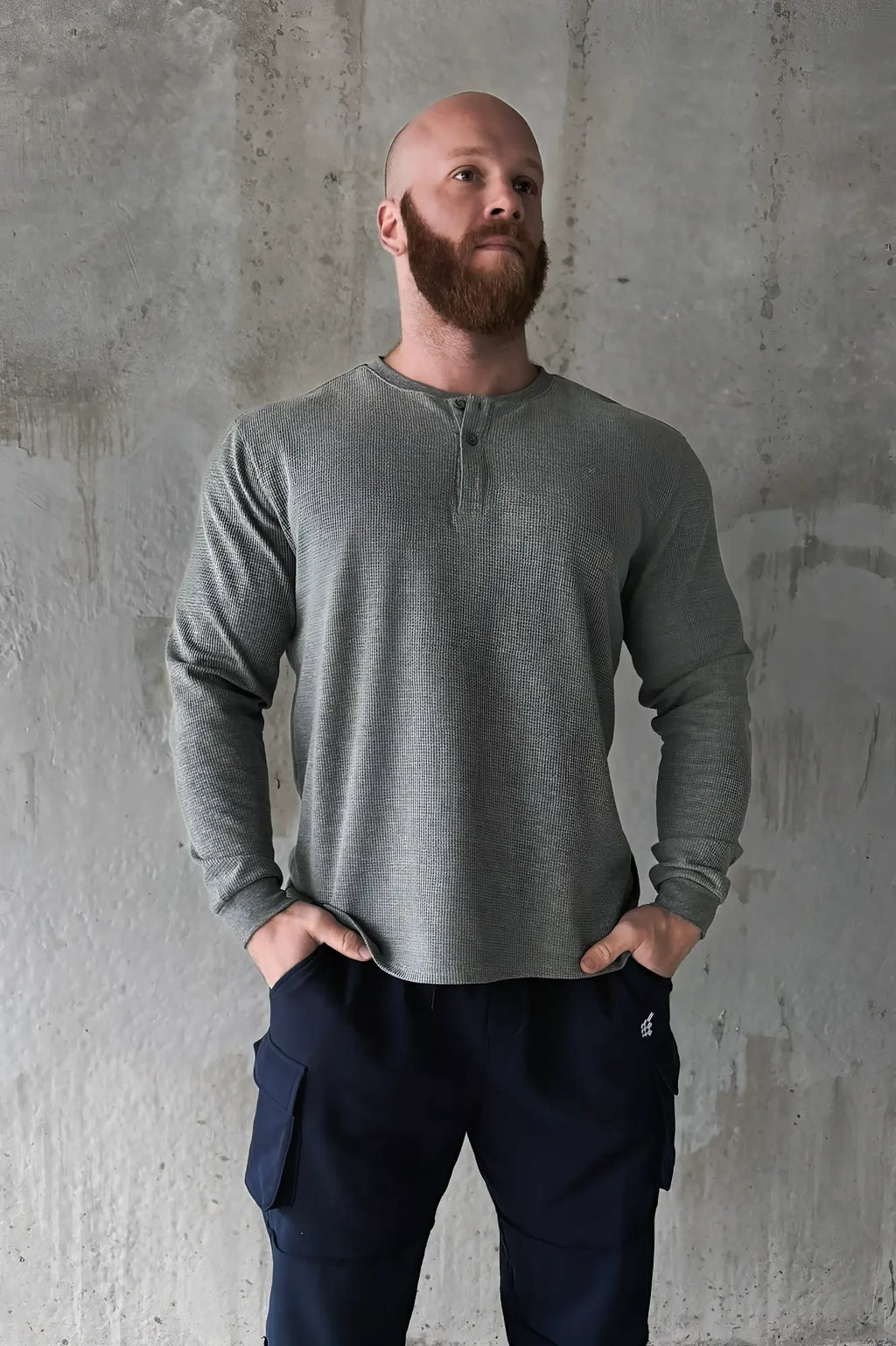 A dark gray waffle knit henley long sleeve t-shirt with ribbed texture and buttoned placket