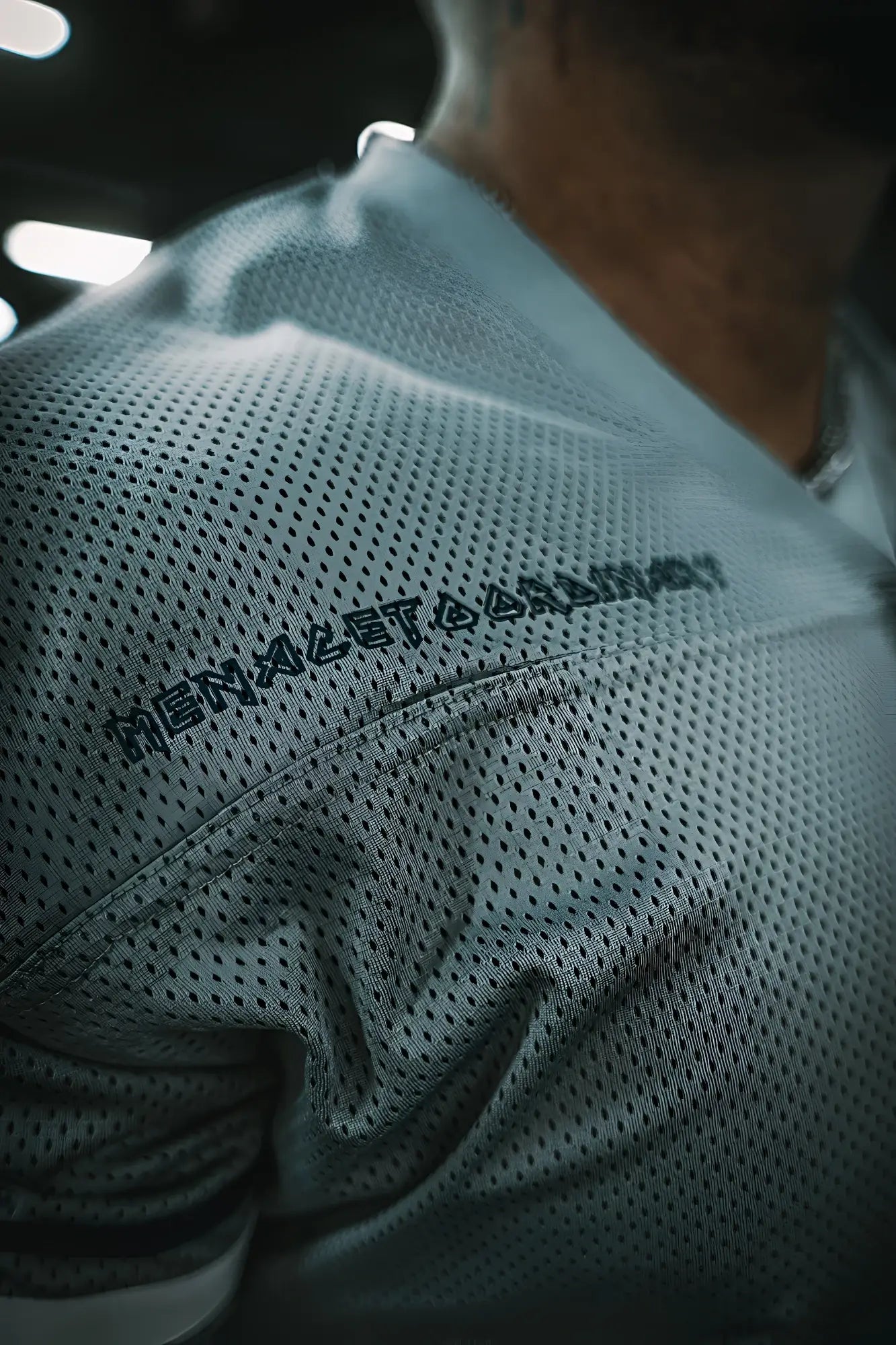 Light gray perforated mesh Jed North Warrior v-neck jersey with black embroidered text across the shoulder