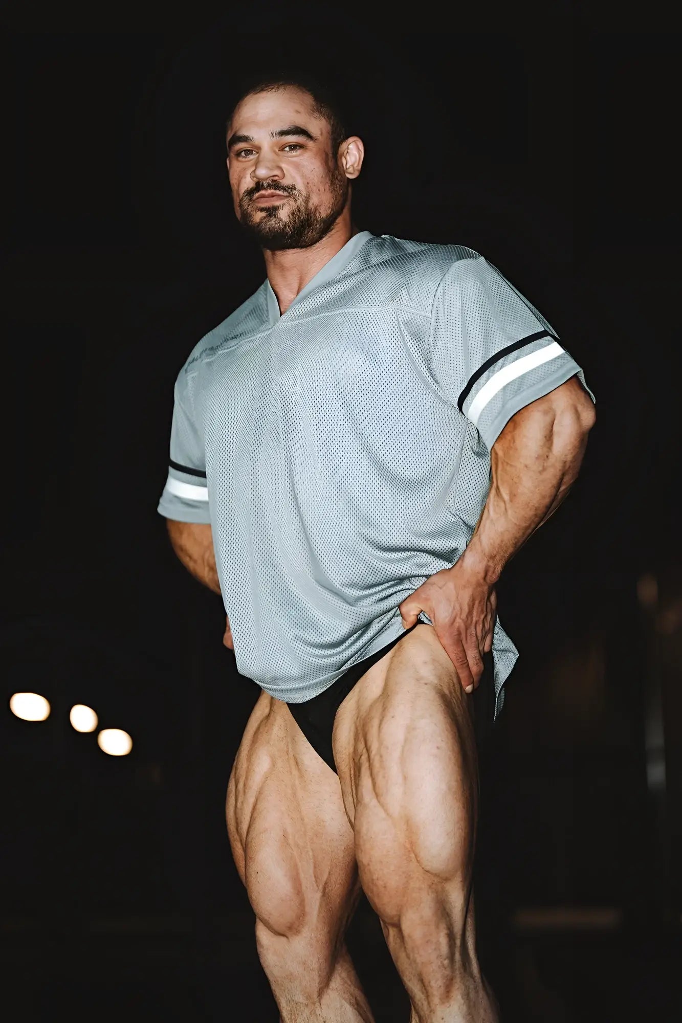 A man wearing a jed north warrior v neck jersey gray in light gray mesh with white and black striped sleeves