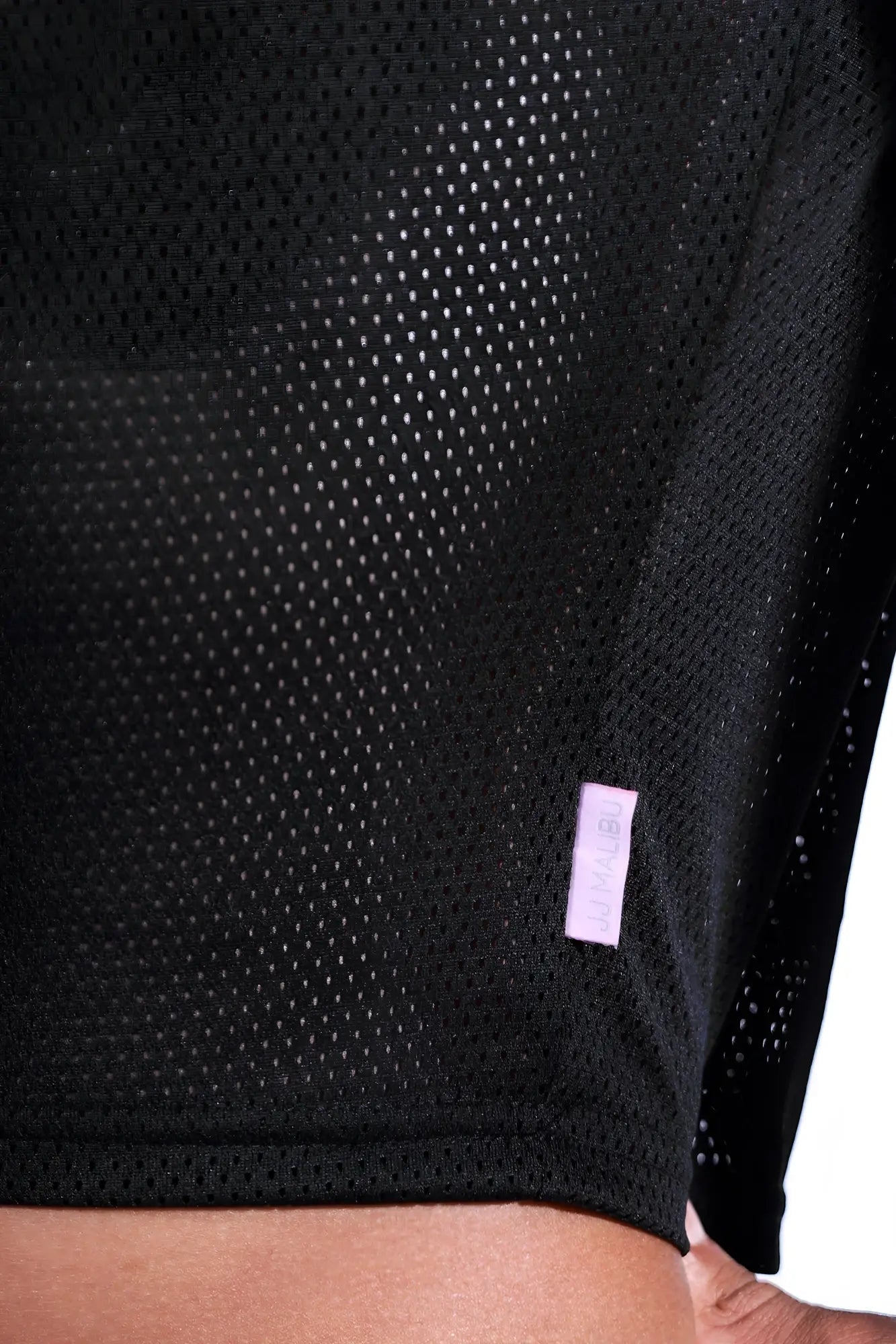 Jersey mesh cropped t-shirt in midnight black with breathable black mesh fabric and a small lavender brand tag at the hem