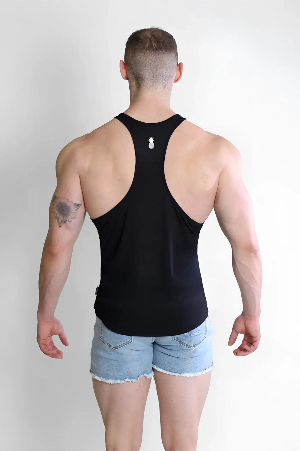 Back view of jj classic workout stringer in malibu black racerback tank top with small white pineapple logo
