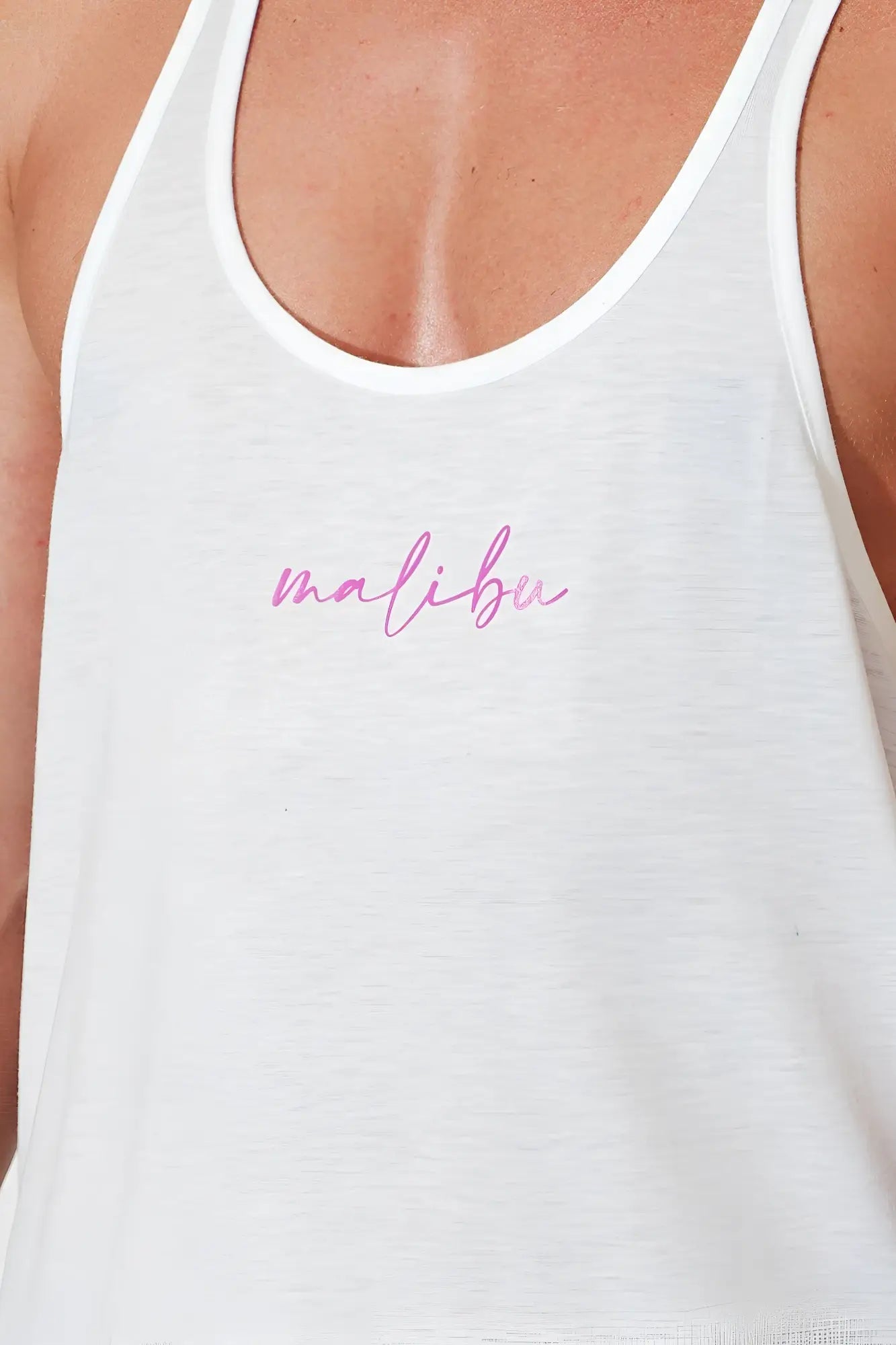 White jj classic workout stringer tank top with pink cursive malibu logo on chest for activewear