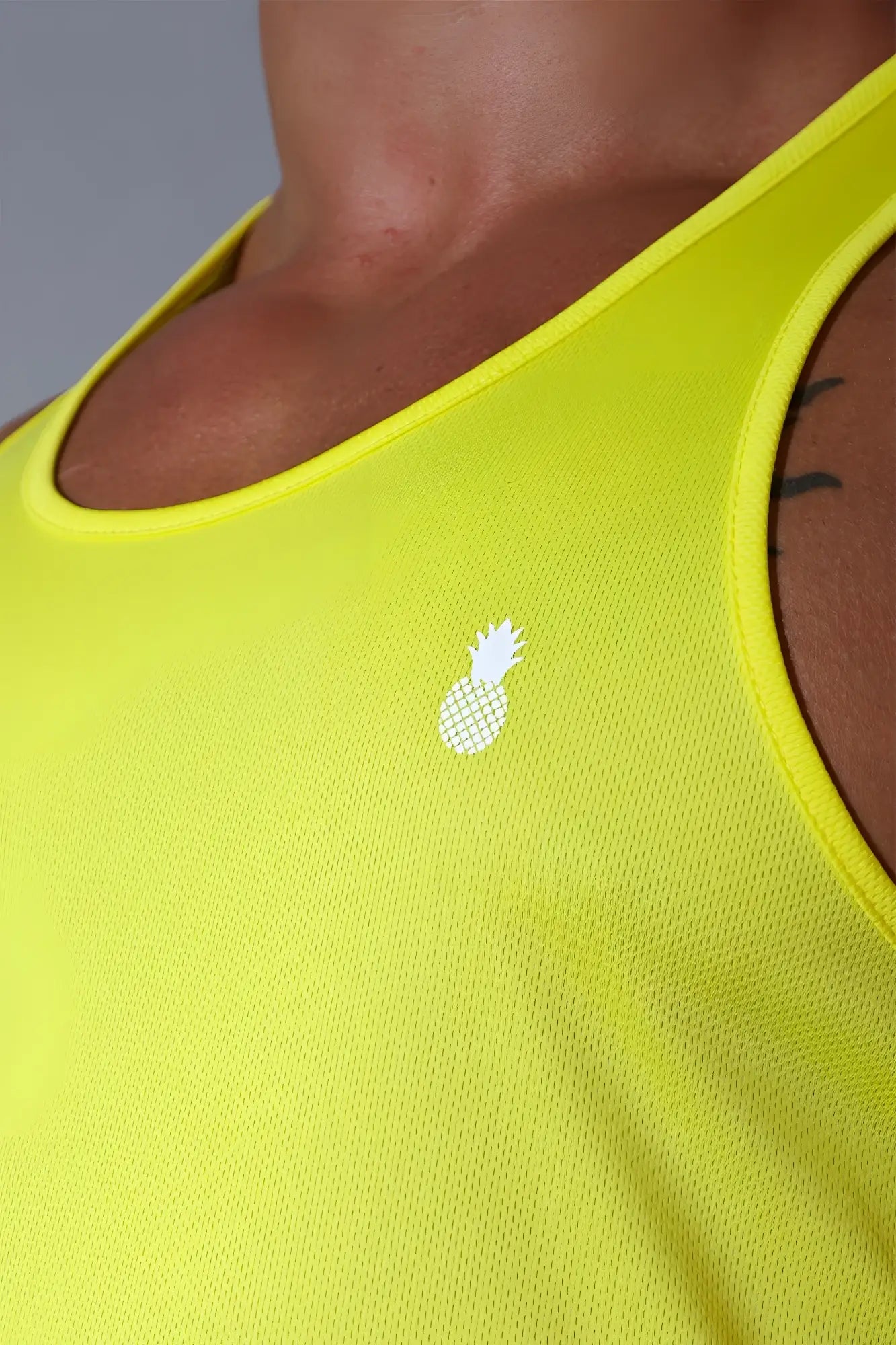 Bright neon yellow jj cool-dry gym stringer tank top with small white pineapple logo made for athletic use