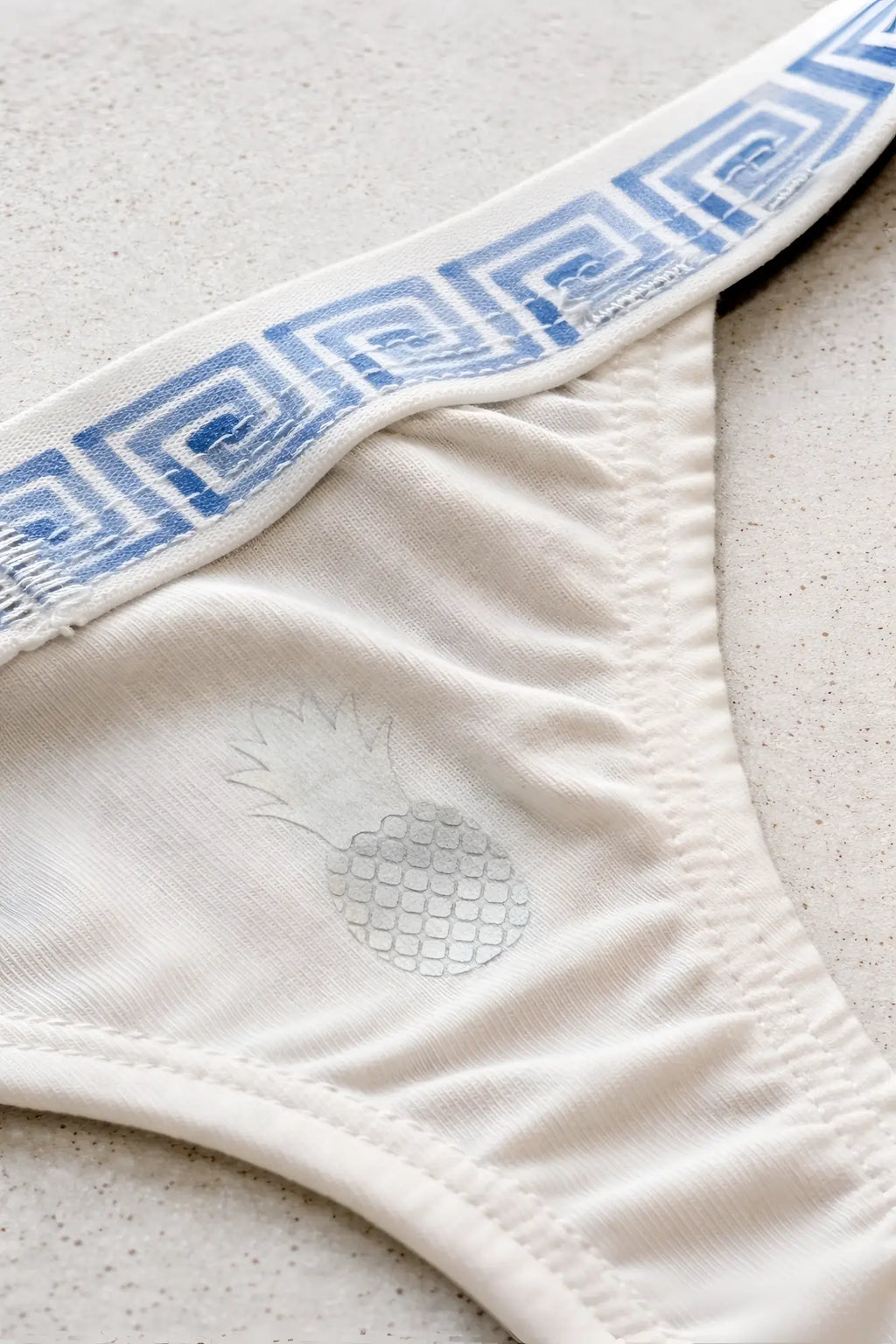 White cotton cheeky classic g-string thong with blue greek key waistband and faint pineapple design on the front