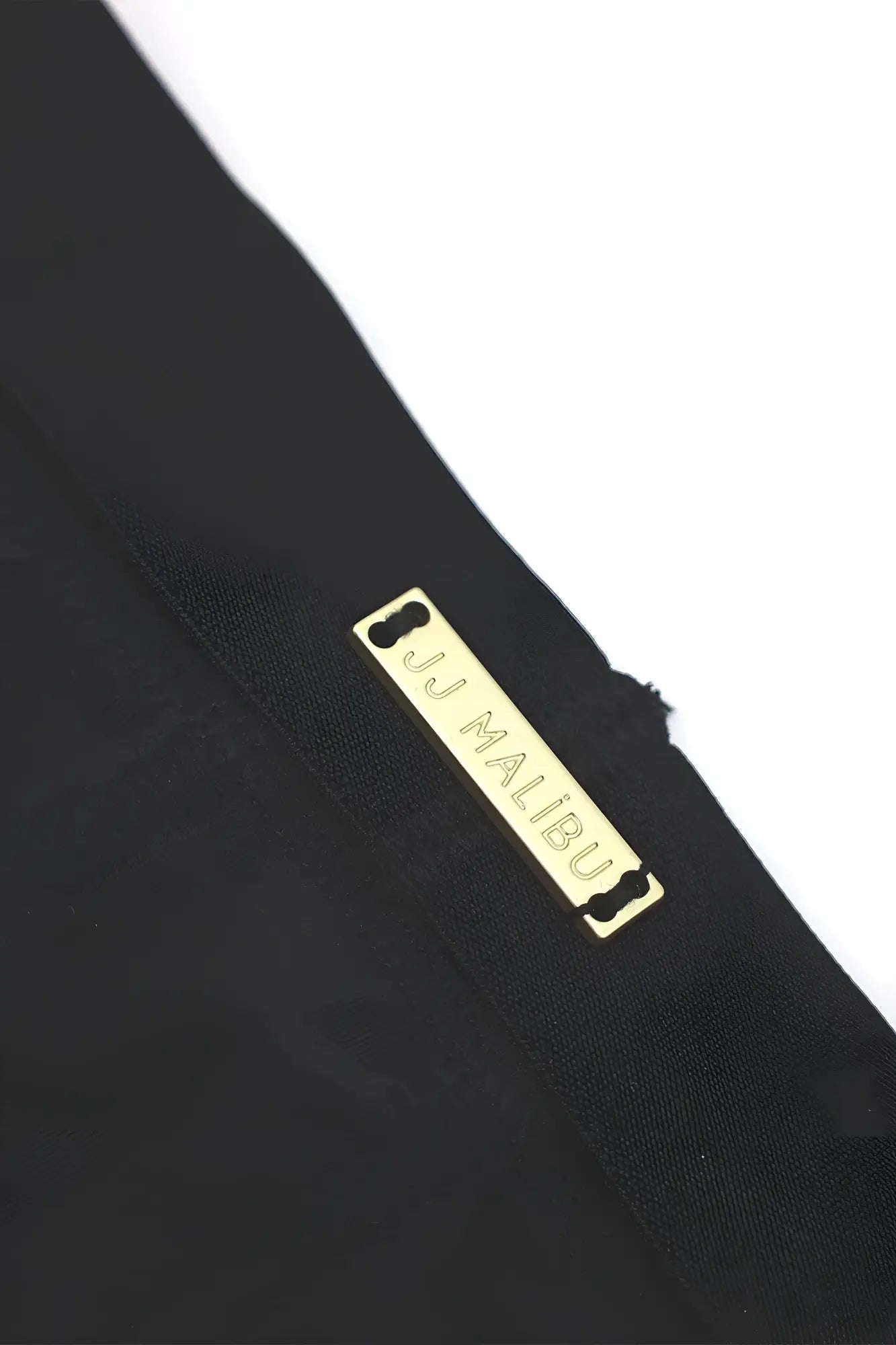 Black on-display jockstrap featuring a gold-tone rectangular jj malibu label on soft fabric