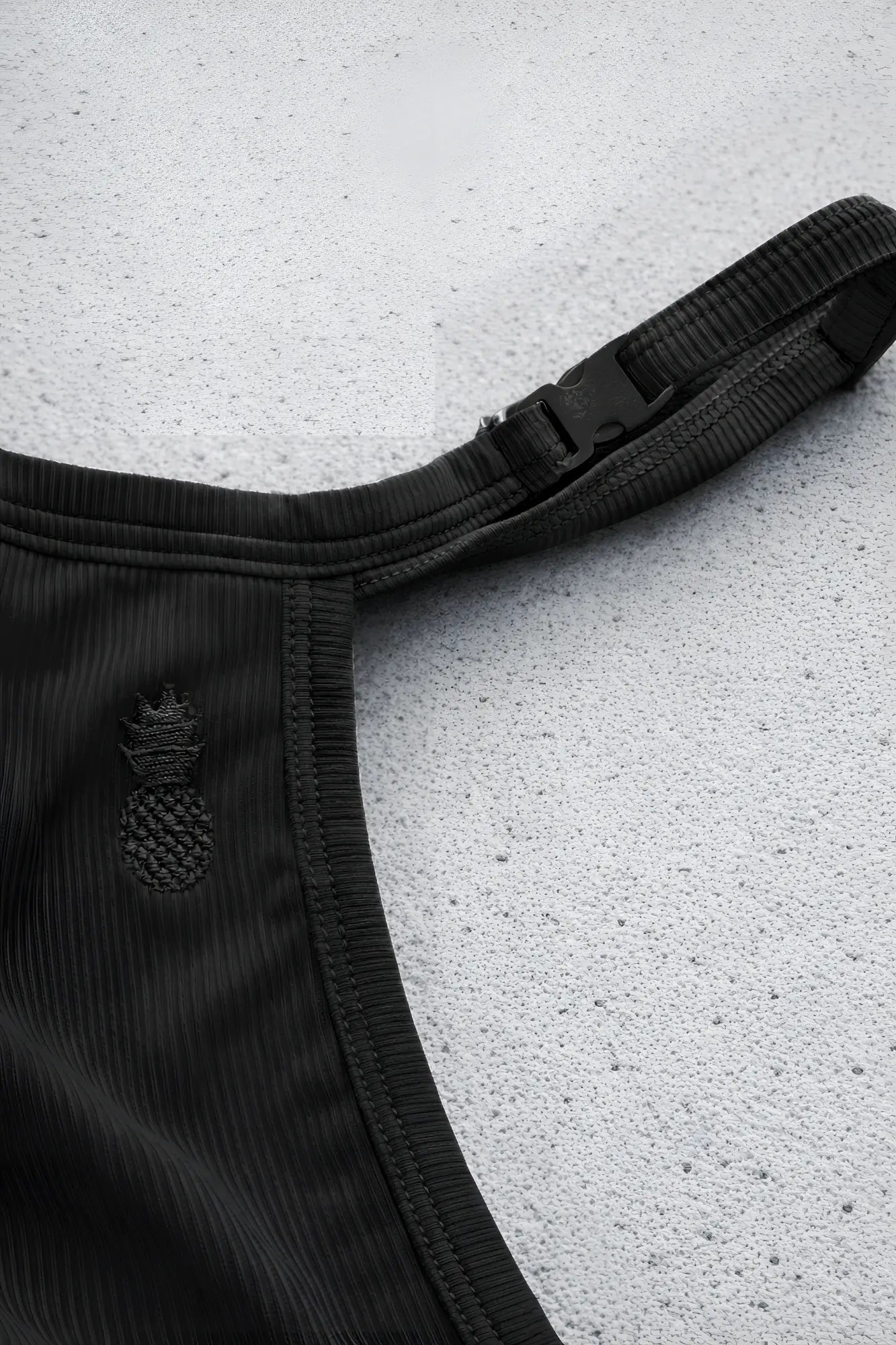 Black corduroy g string v back jockstrap with subtle pineapple embroidery detail in pitch black color showing back side