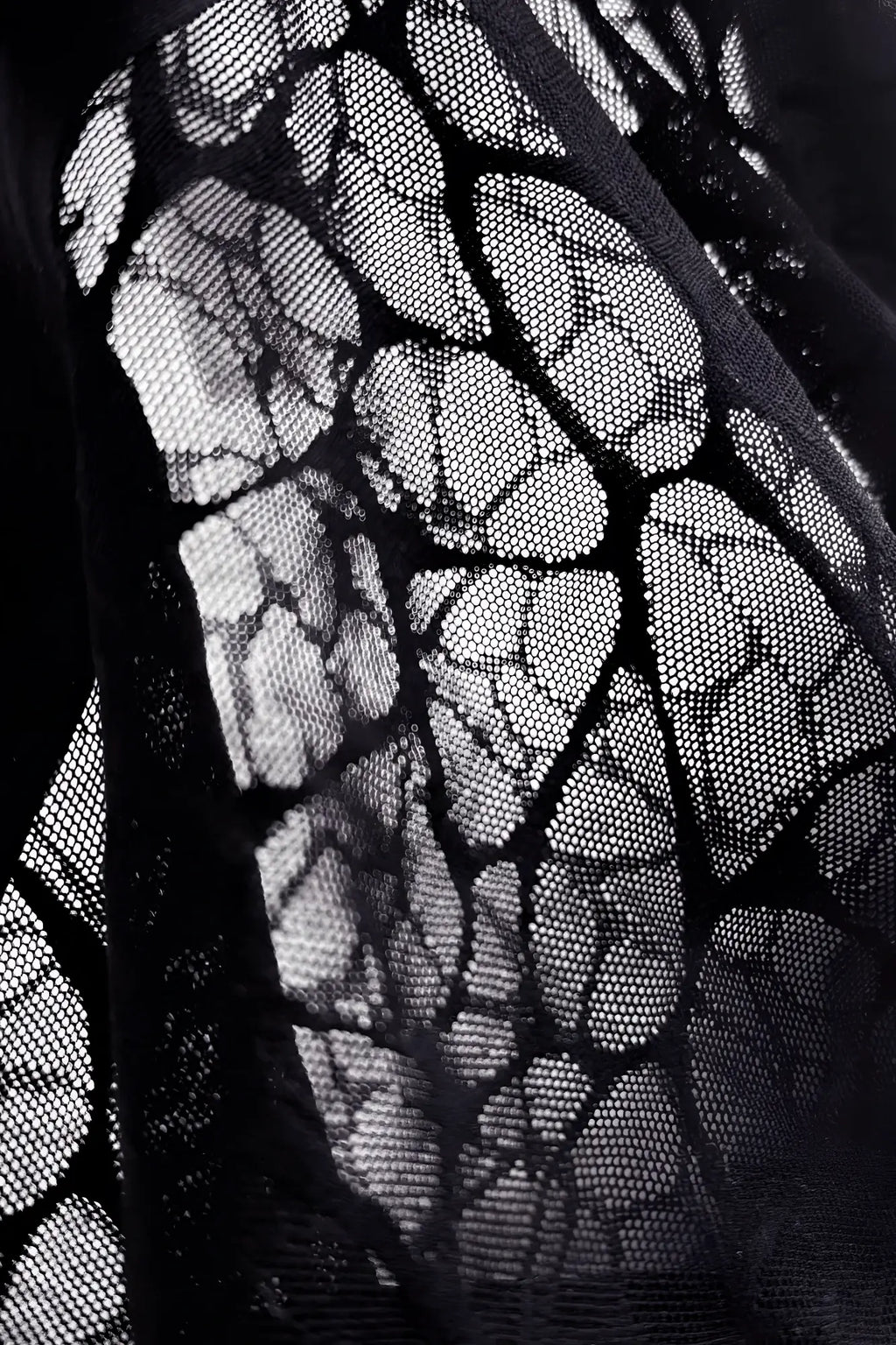 Charcoal black geo-mesh seamless boxers made of black lace fabric with delicate leaf-like pattern and fine mesh texture