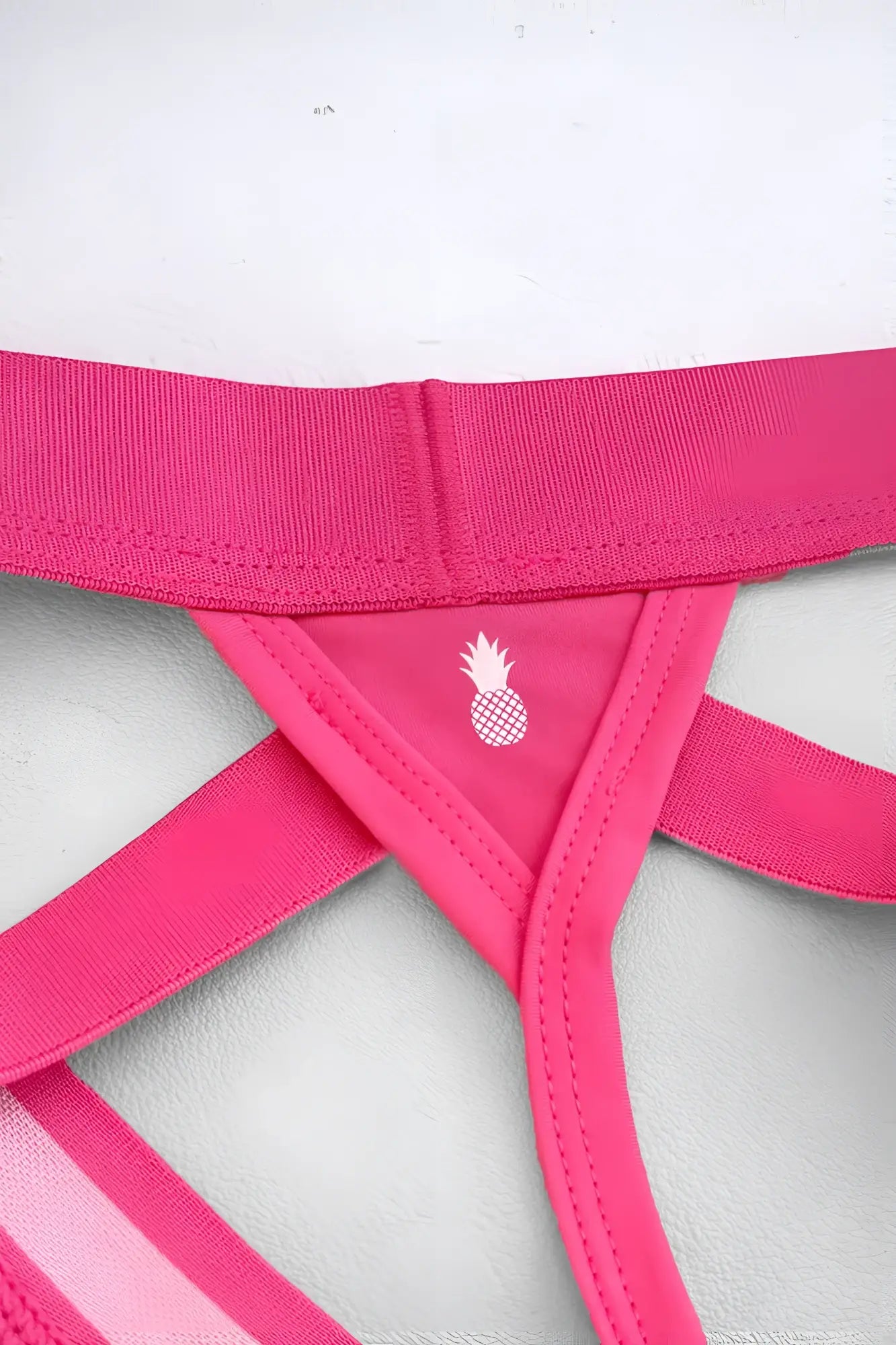 Bright pink host or travel adjustable athletic-style jock thong with white pineapple logo on inner triangle