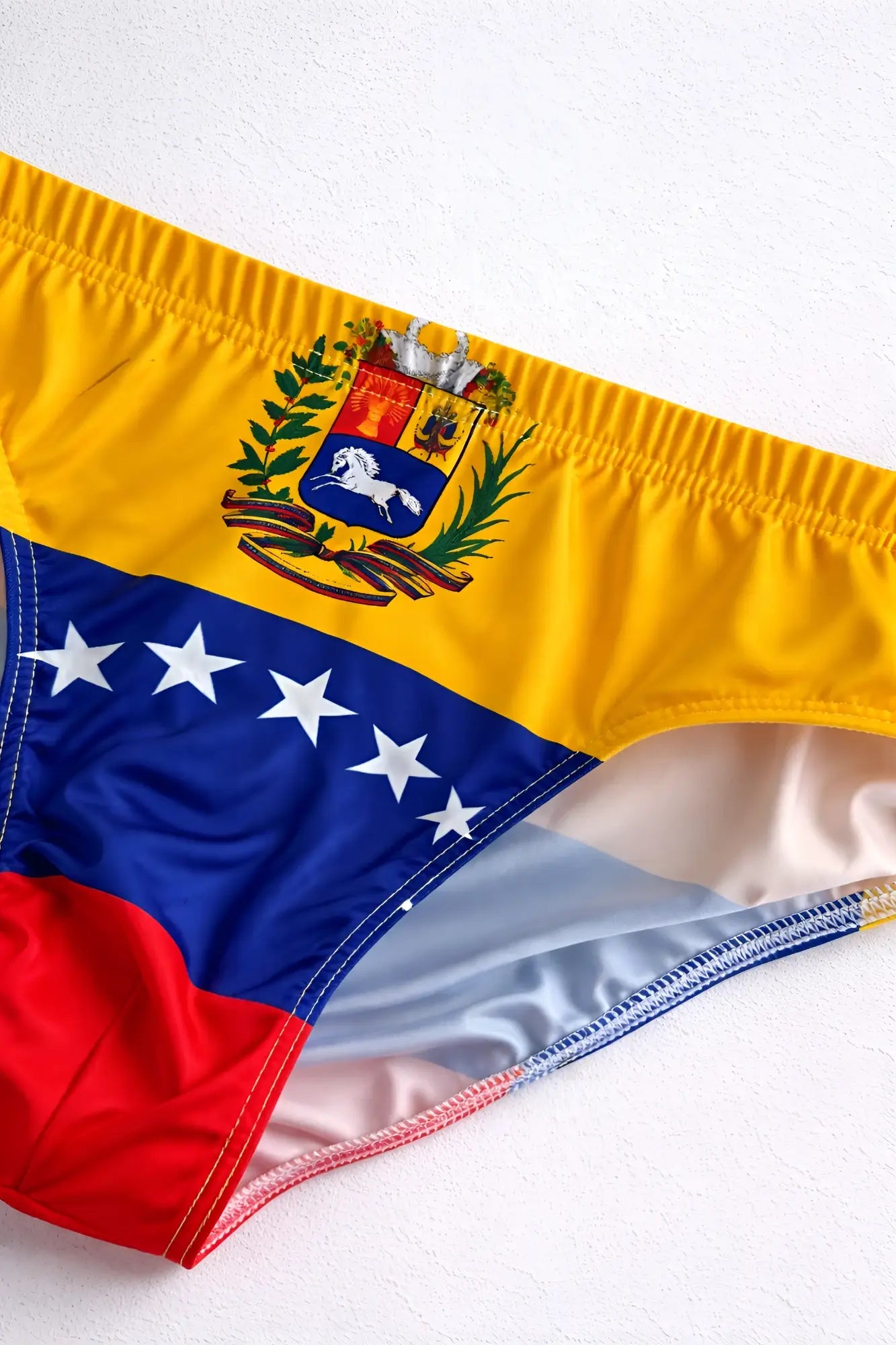 Lovesick briefs venezuela flag swim trunks in vibrant yellow blue and red with detailed national emblem design