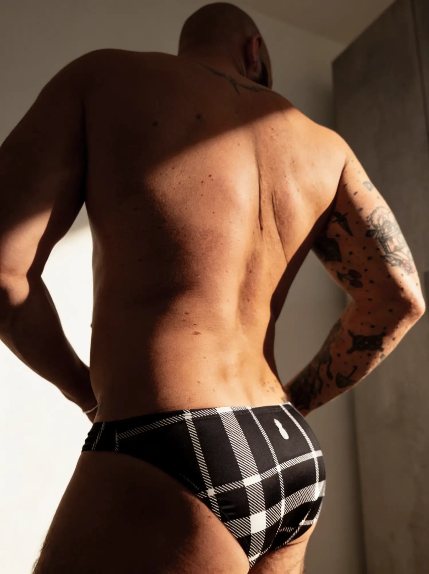 Men’s slimmer bulge briefs in black and white plaid showing back with subtle logo for comfortable everyday wear