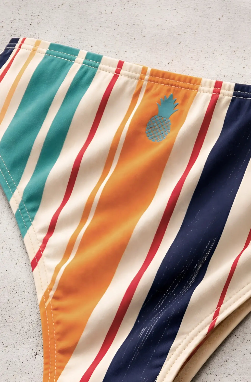 Men’s slimmer bulge briefs with vibrant teal orange red navy stripes on cream featuring embroidered pineapple detail