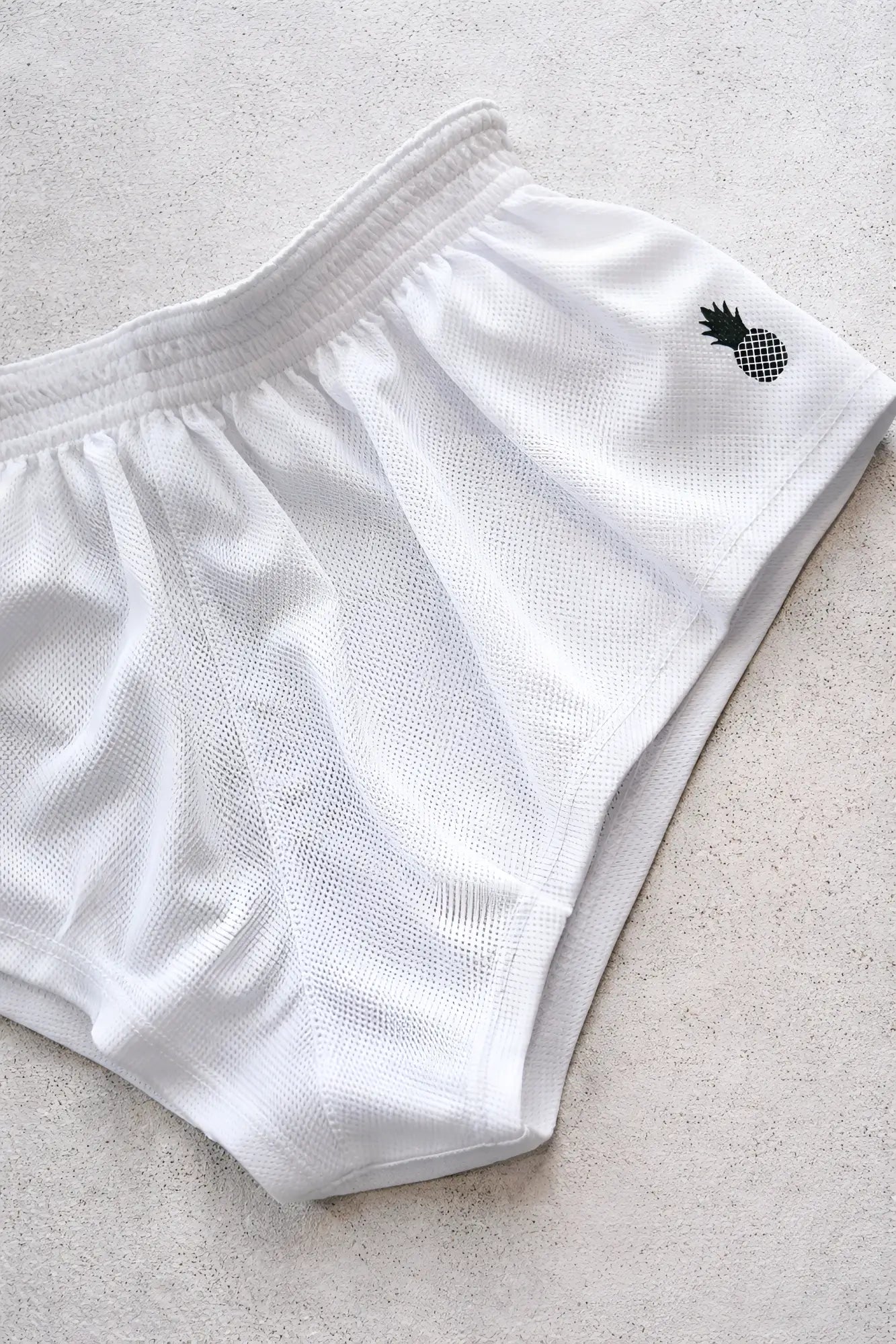 White mesh stretch-it 2 quick-dry athletic shorts with black pineapple logo embroidered on the side