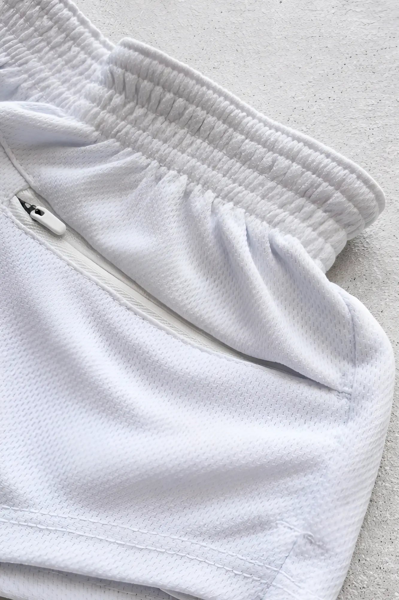 White mesh stretch-it 2 quick-dry short shorts with ribbed elastic waistband and small zippered pocket for athletic use