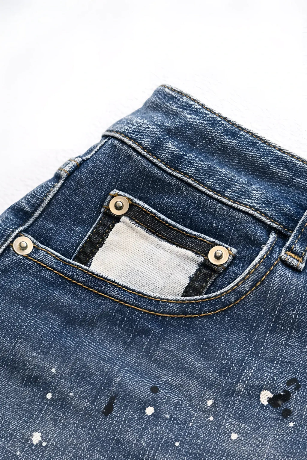 Dark blue studio splash 1.5 inch denim short shorts with distressed paint splatter and silver rivets on back pocket visible
