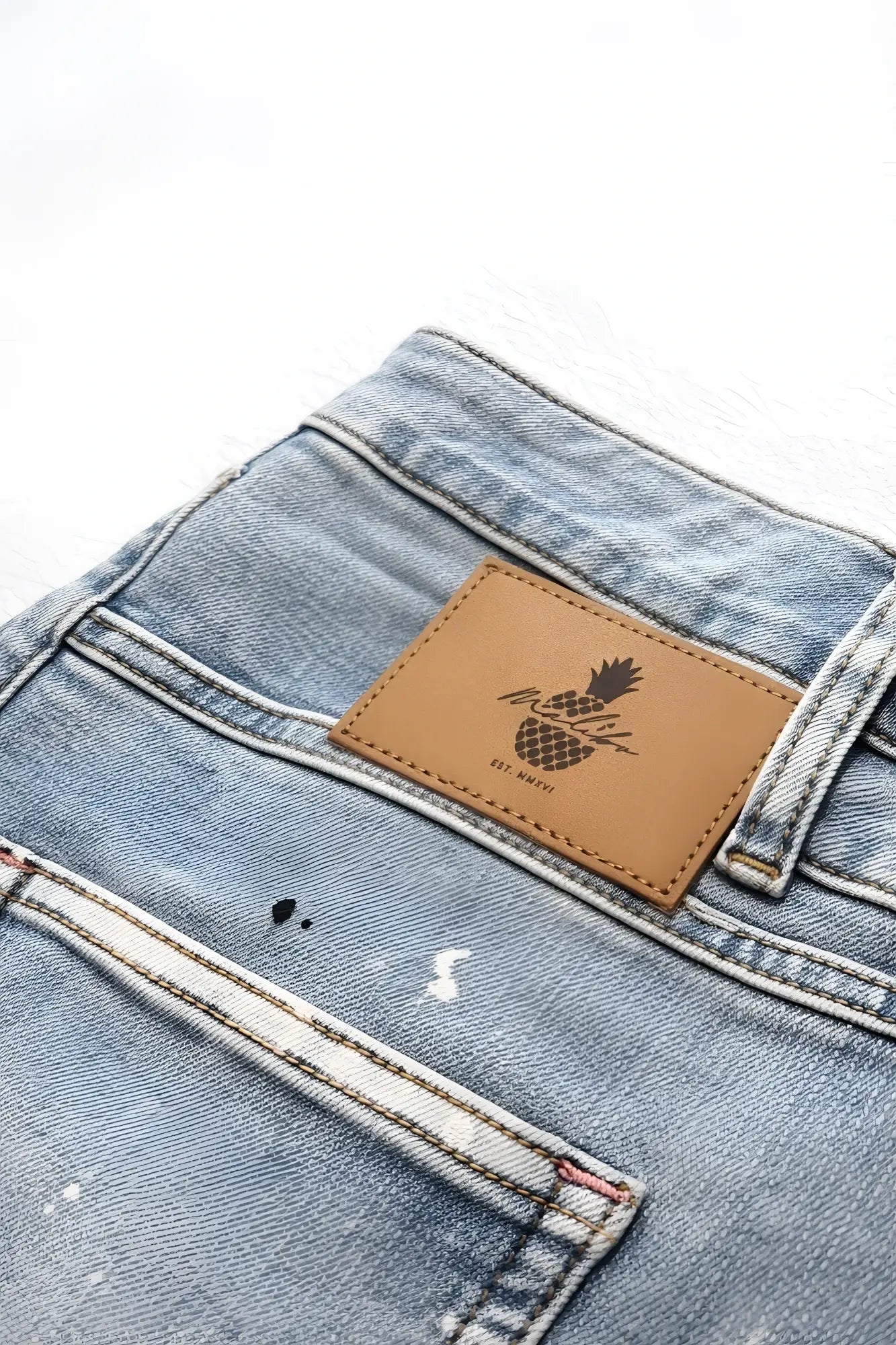 Light-wash denim studio splash 1.5 inch short shorts in sky blue with brown leather patch and diesel pineapple logo on the back