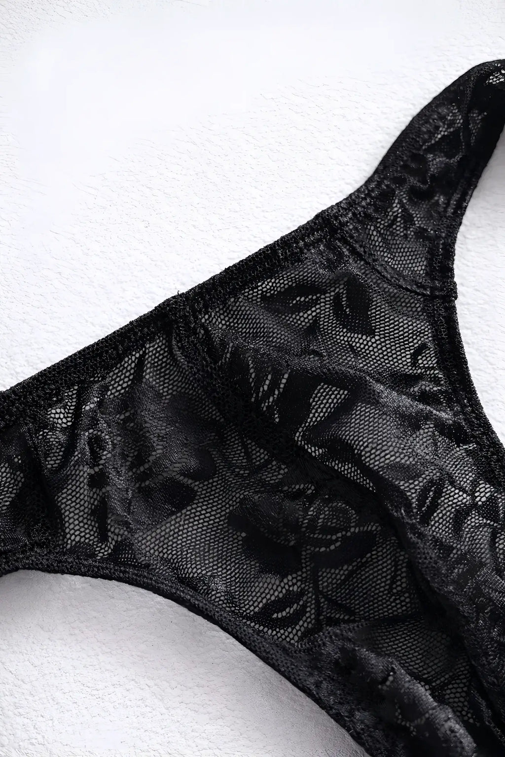 Black veiled floral lace thong with sheer mesh design and intricate floral patterns for elegant lingerie wear