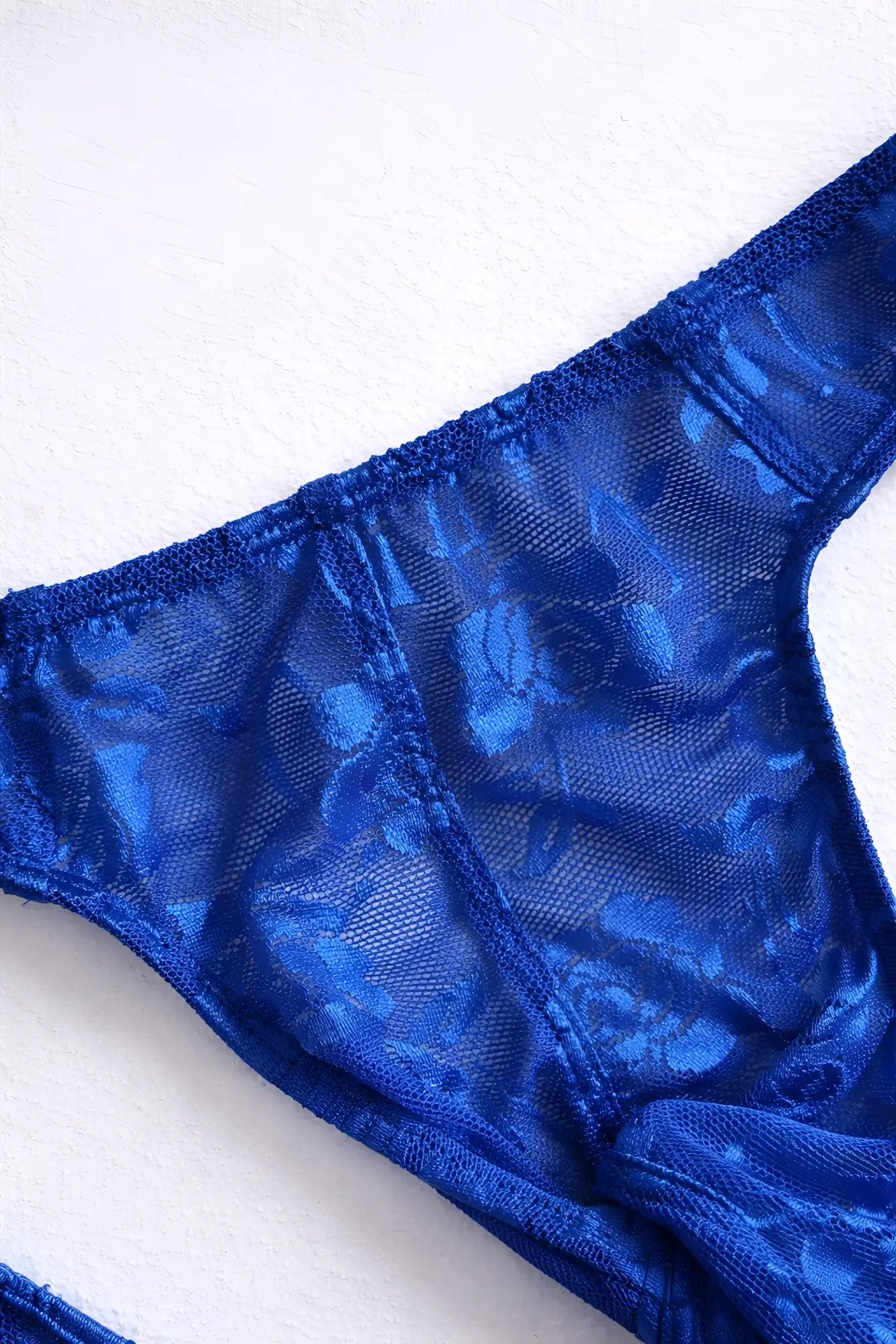 Veiled floral lace thong in royal blue with sheer floral pattern and satin like finish