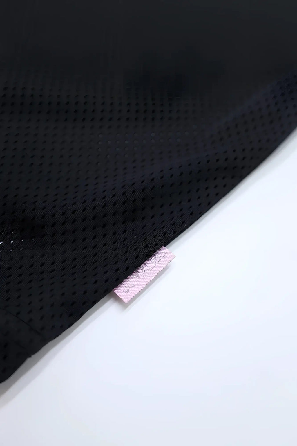 Jj varsity v-neck jersey black showing black perforated mesh fabric with a small pink tag detail