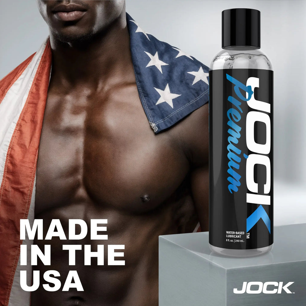 Jock 8oz Premium water-based lubricant bottle with black label, next to a muscular man draped in an American flag.